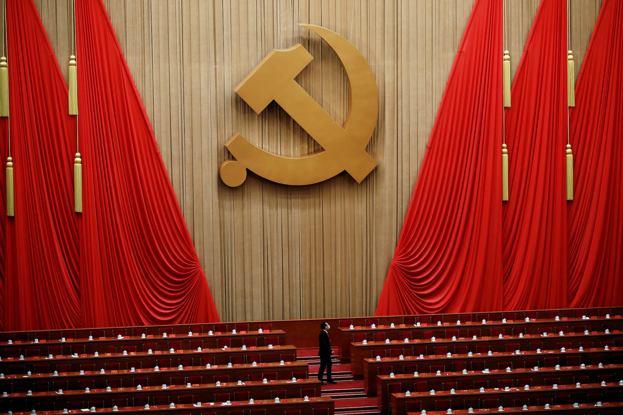A man stands under the Chinese Communist Party emblem at the end of the closing ceremony on October 22.