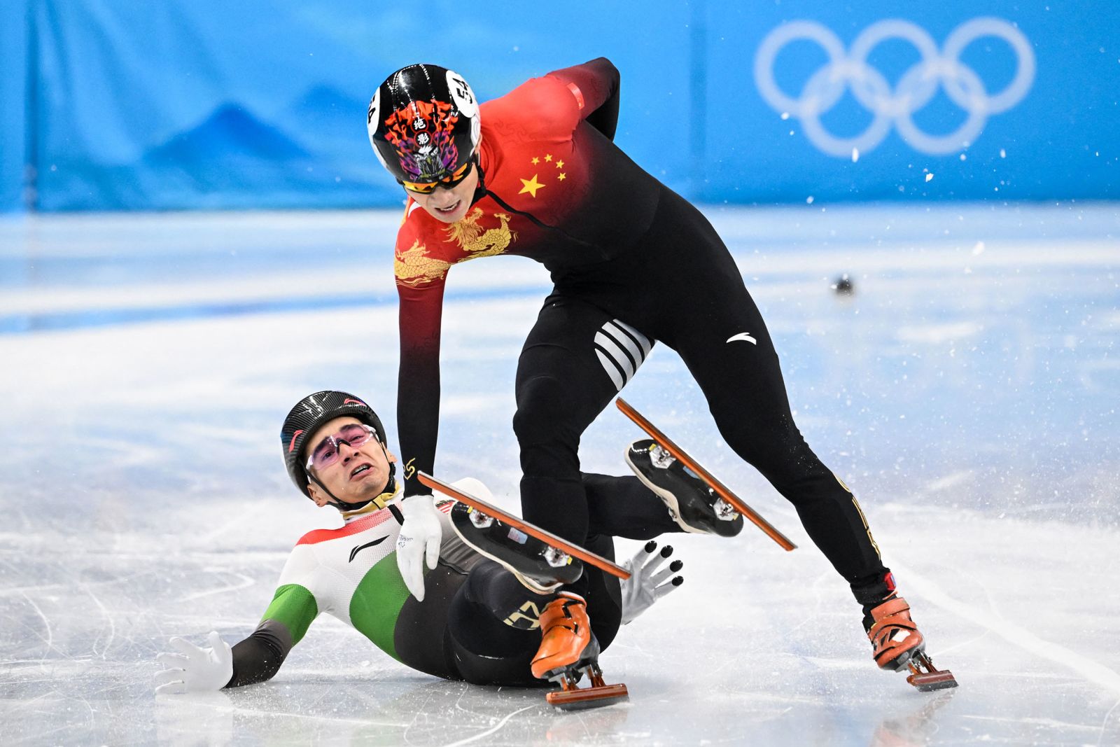 From left, Hungary's Shaolin Sándor Liu gets tangled up with China's Ren Ziwei after crossing the finish line in the 1,000-meter short track final. Liu crossed the finish line first, but Ren was awarded the gold medal after Liu was given a yellow card and two penalties for illegally changing lanes and causing contact with Ren.