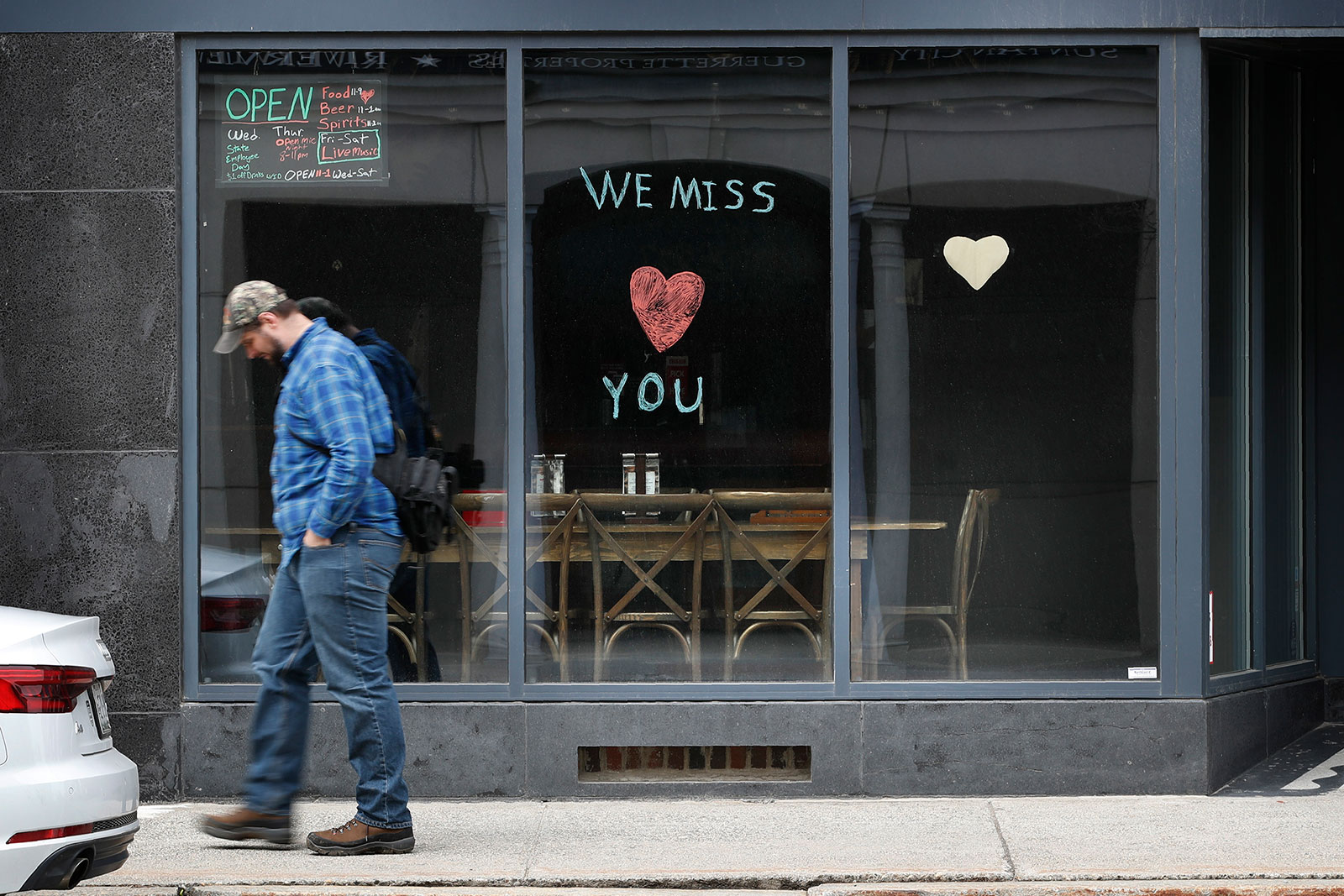 A man walks by the Raging Bull Saloon in Augusta, Maine, on April 28.