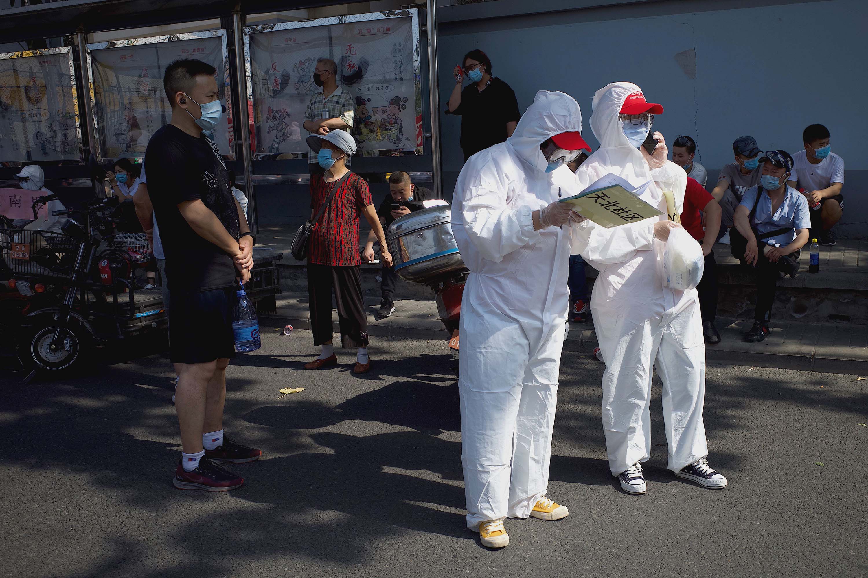 Medical staff stand by outside a sports center in Beijing, on Tuesday, June 16, where testing is being carried out on those who live nearby or who have visited the Xinfadi Market, which has been linked to a new coronavirus cluster.