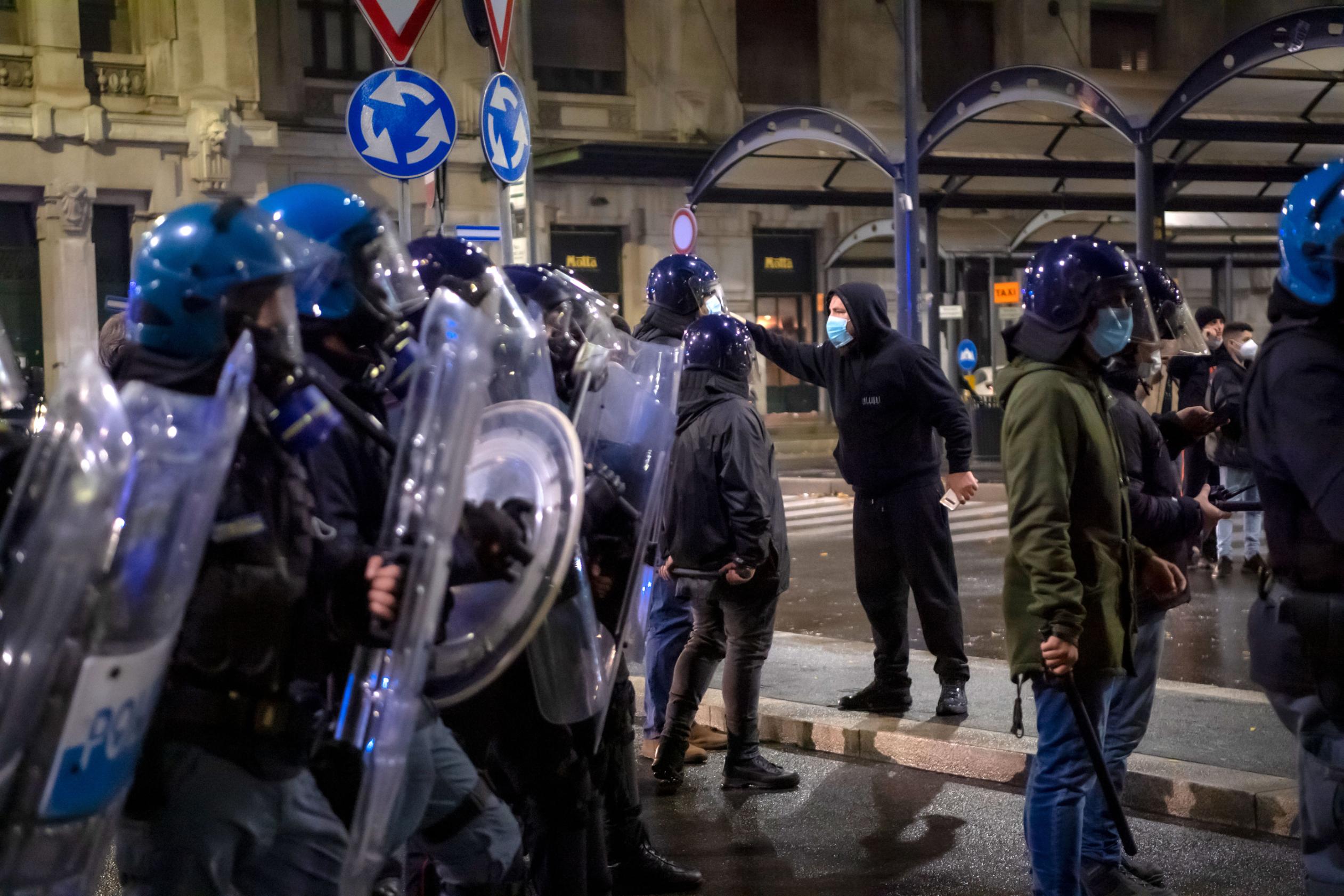 A protester confronts police officers and the Carabinieri during a coronavirus restrictions protest on October 26 in Milan, Italy. 