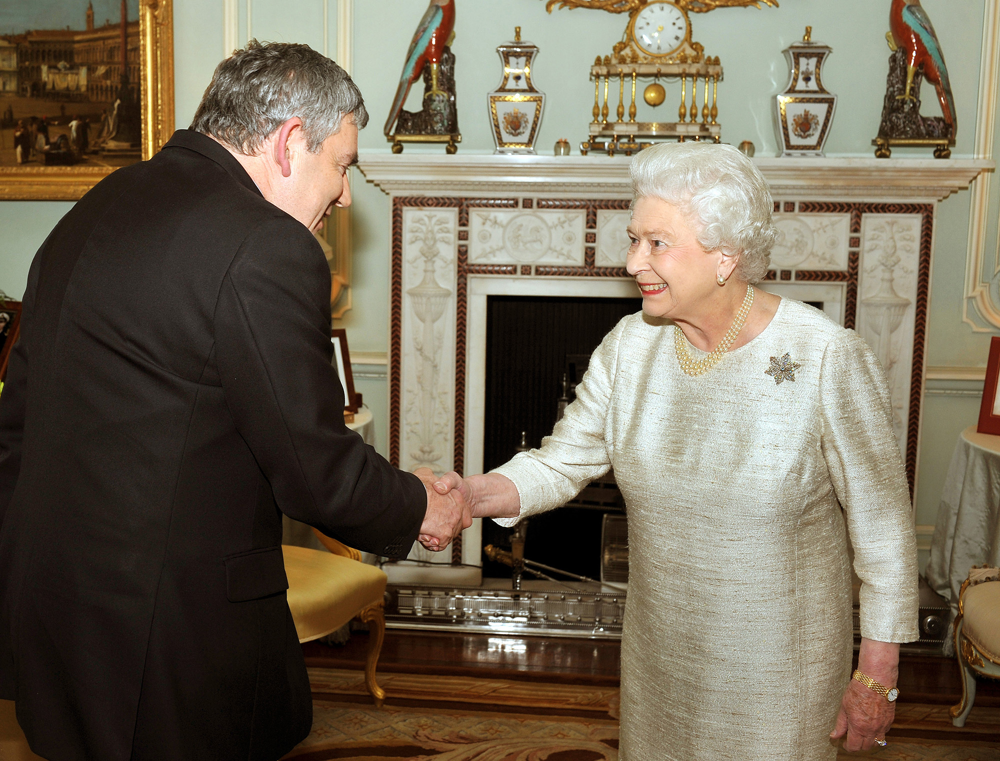 Britain's outgoing Prime Minister Gordon Brown is greeted by Queen Elizabeth in a meeting in which he tendered his resignation at Buckingham Palace in London, England, on May 11, 2010.