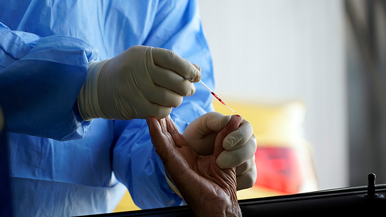 A health worker administers a coronavirus test at a drive-thru testing facility in the central Iraqi city of Najaf, on July 15, 2020. 