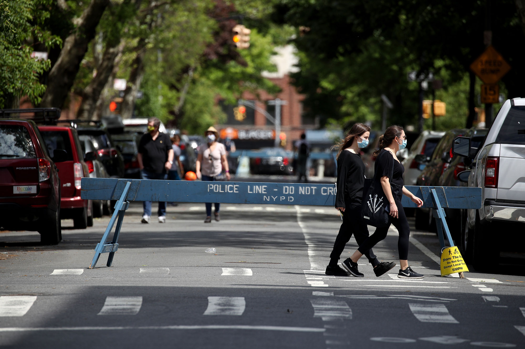 Pedestrians walk past a closed off street during the coronavirus pandemic on May 17 in the Cobble Hill neighborhood of the Brooklyn borough of New York City. 
