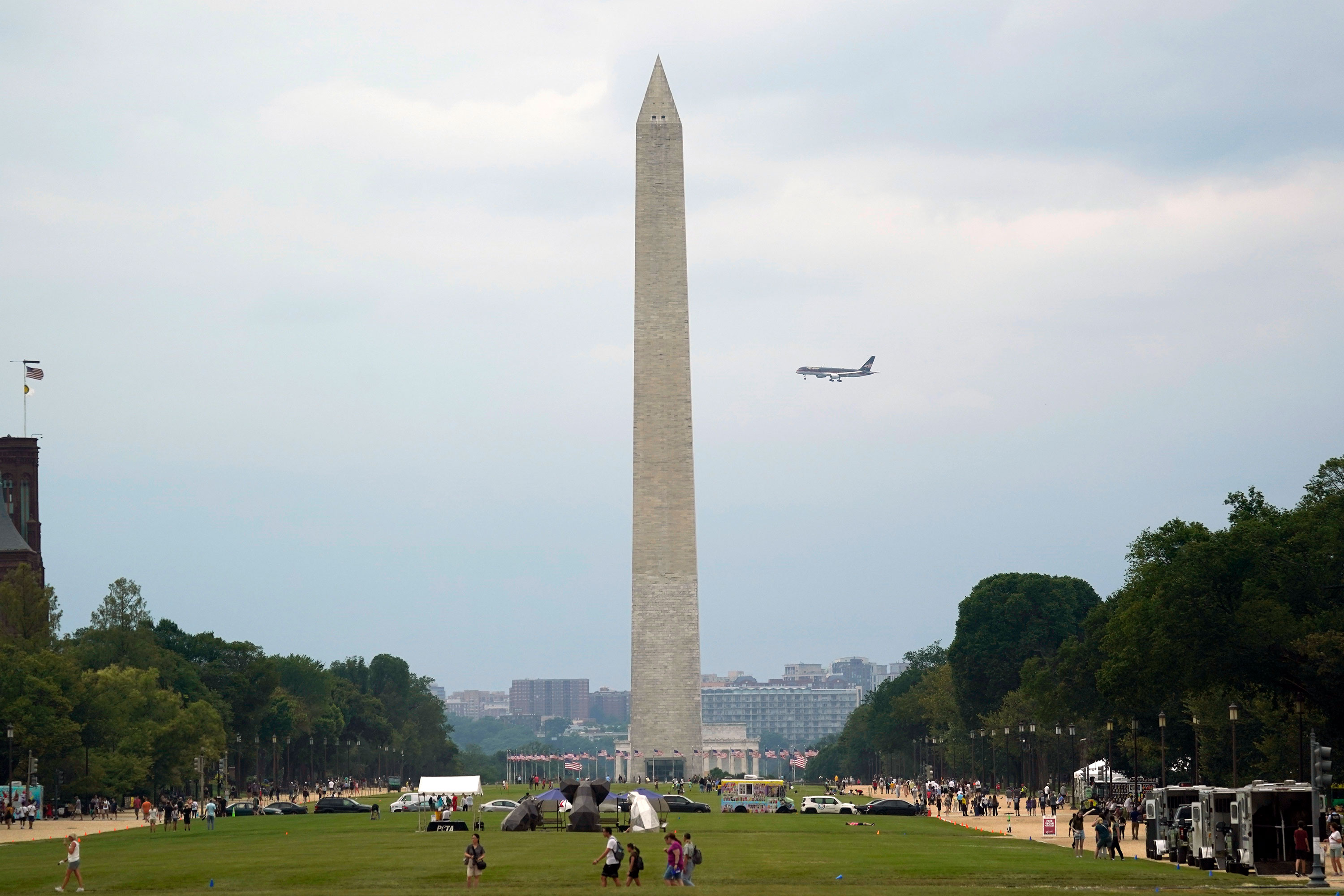 Former President Donald Trump's airplane flies behind the Washington Monument as it makes its final approach into Reagan National Airport on Thursday.