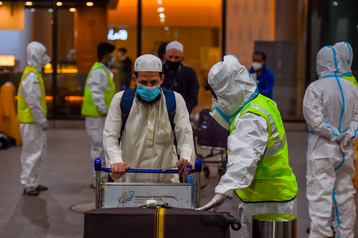 Health workers watch as passengers arrive at the Chhatrapati Shivaji International Airport from London on December 22.