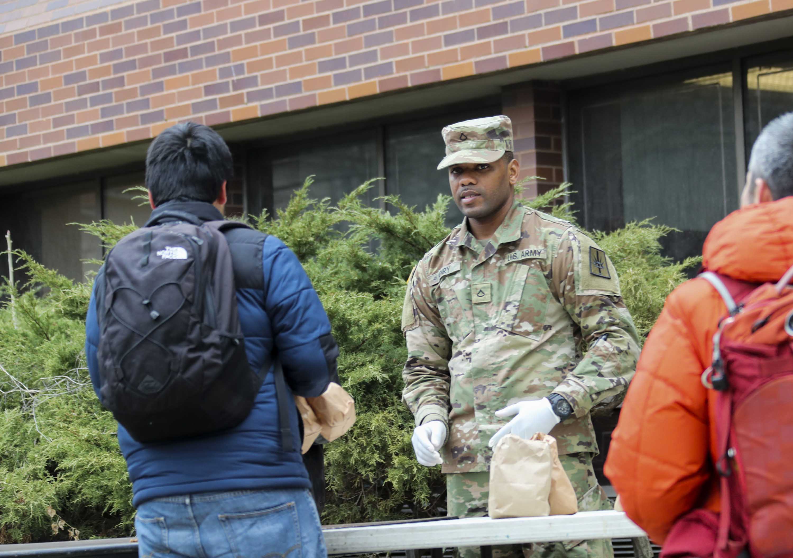 A member of the National Guard distributes food to residents near the containment zone in New Rochelle, New York, on March 12.
