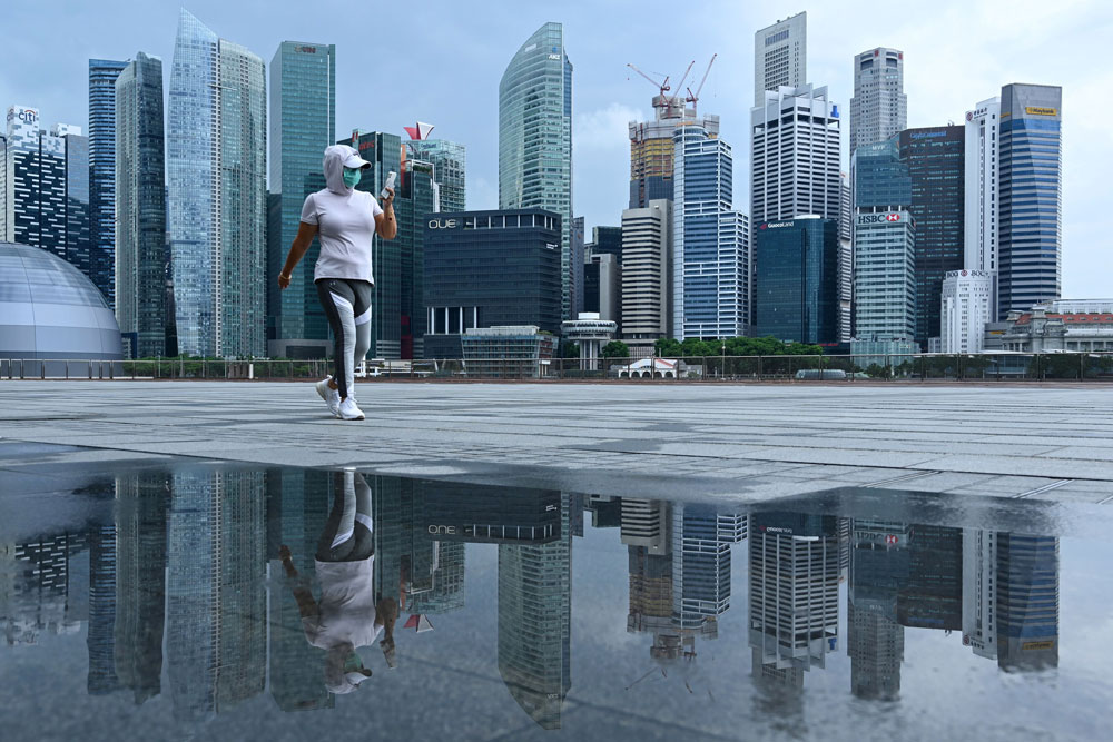 A woman wearing a face mask walks along a promenade in Singapore on May 4.