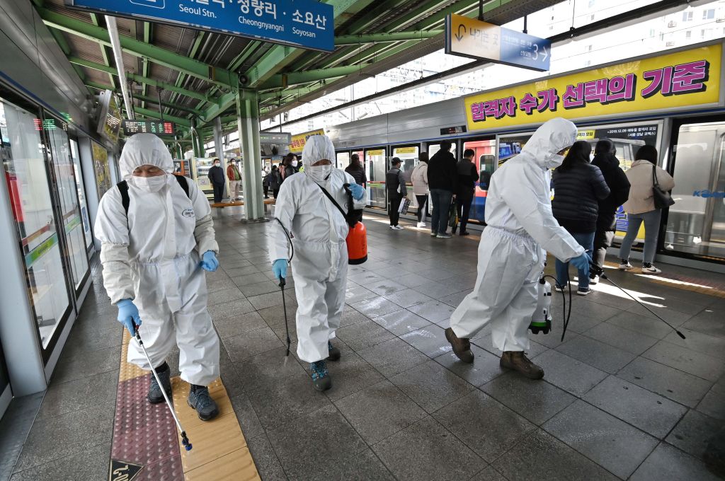 Workers spray disinfectant at a subway station in Seoul, South Korea, on Friday.