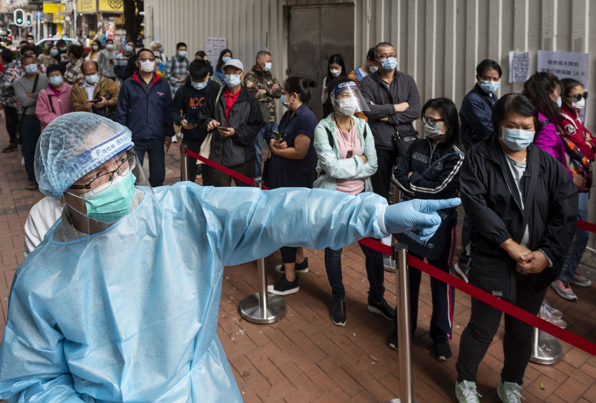 A health worker organizes the visitors' queue lines outside a Community Testing Centre in Hong Kong on Nov. 30.