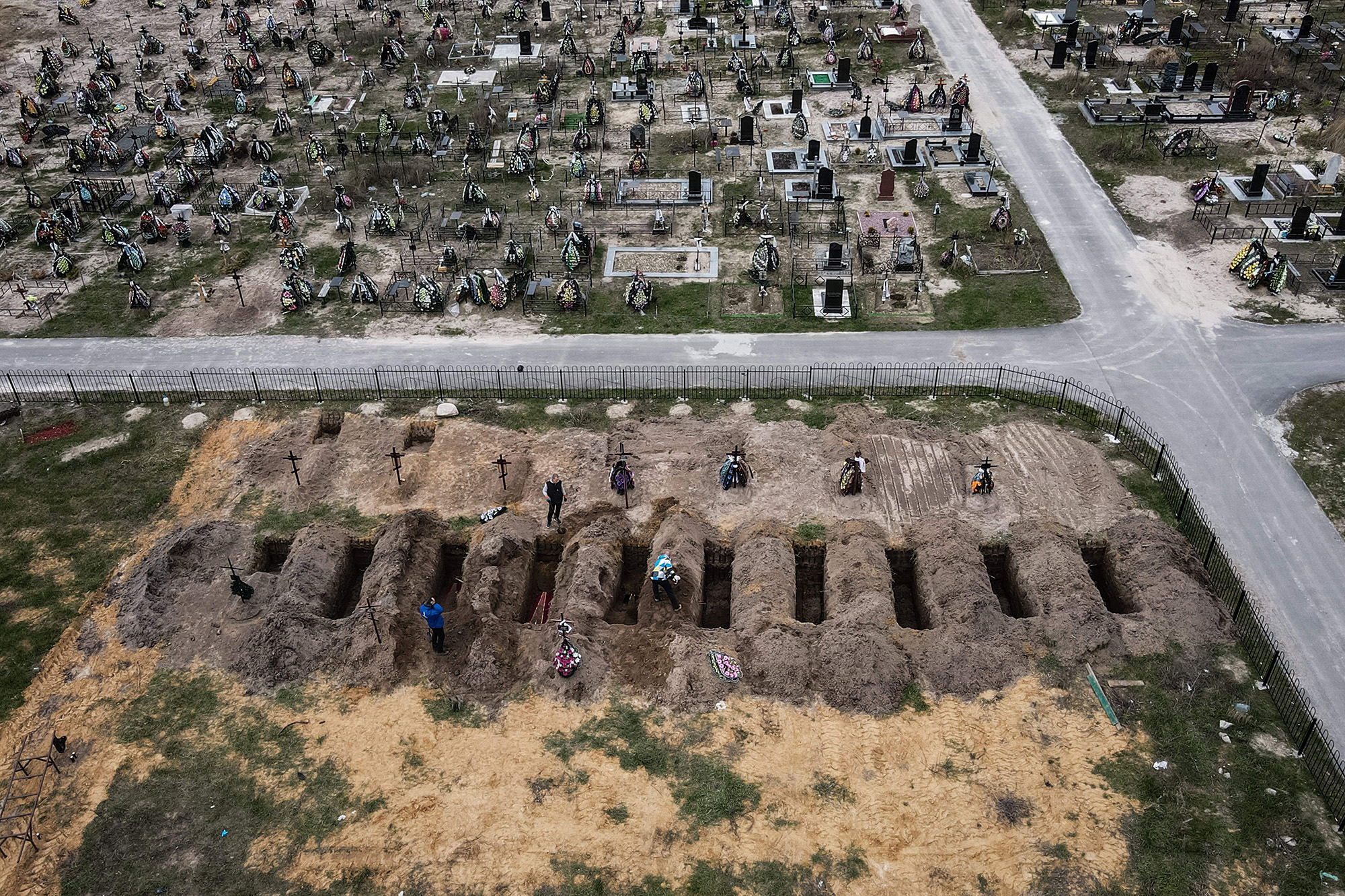 Coffins being buried during a funeral ceremony at a cemetery in Bucha, Ukraine, on April 18.