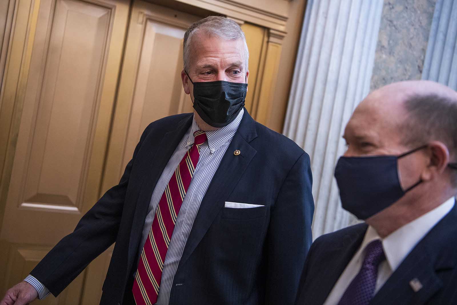 Sen. Dan Sullivan and Sen. Chris Coons are seen outside the chamber as the Senate votes to open debate on the coronavirus relief package on Thursday, March 4.