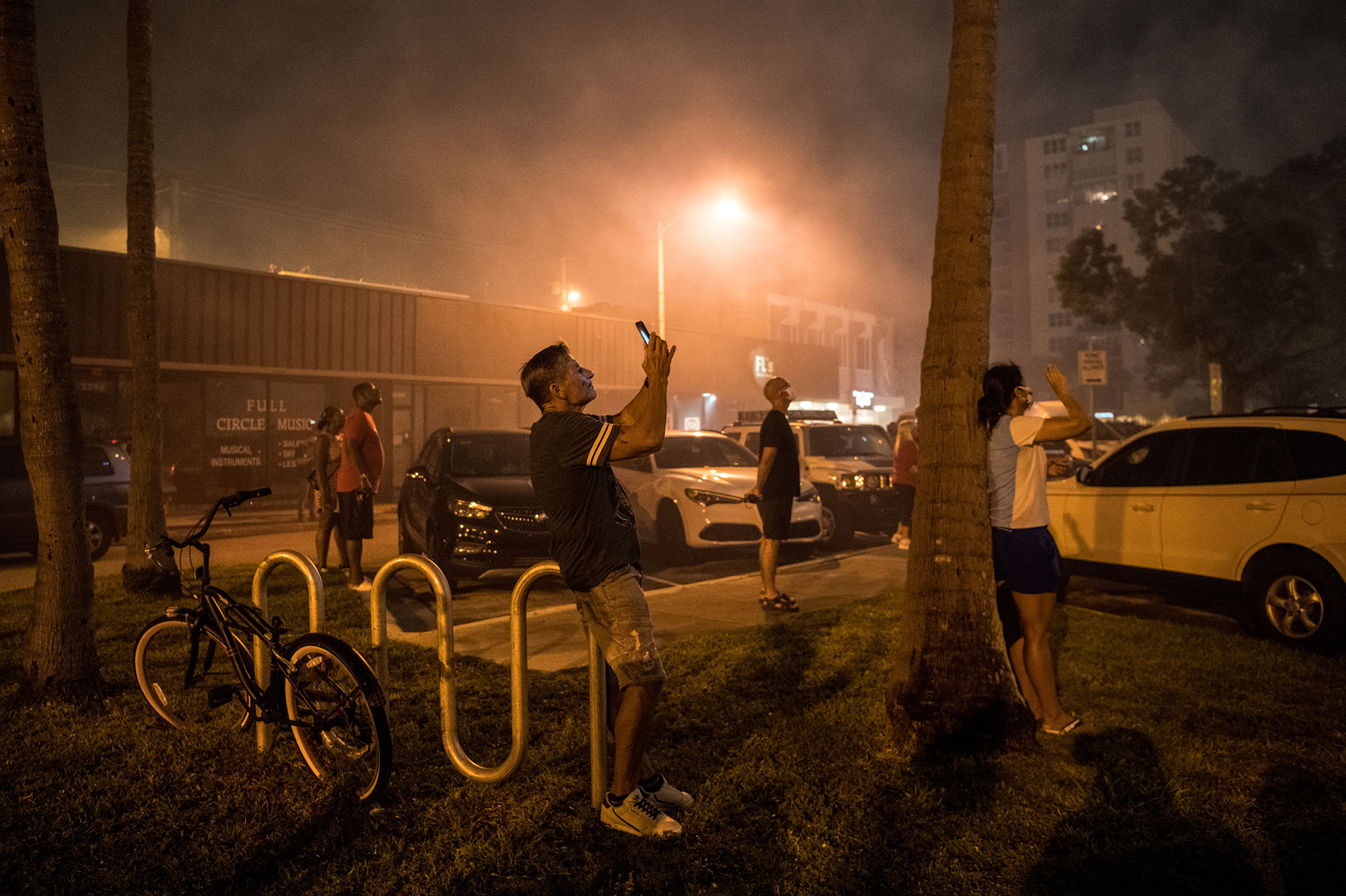 People gather on the street as they watch fireworks burst during Independence Day celebrations in Fort Lauderdale, Florida on July 4, 2020. Fort Lauderdale is the county seat of Broward County.