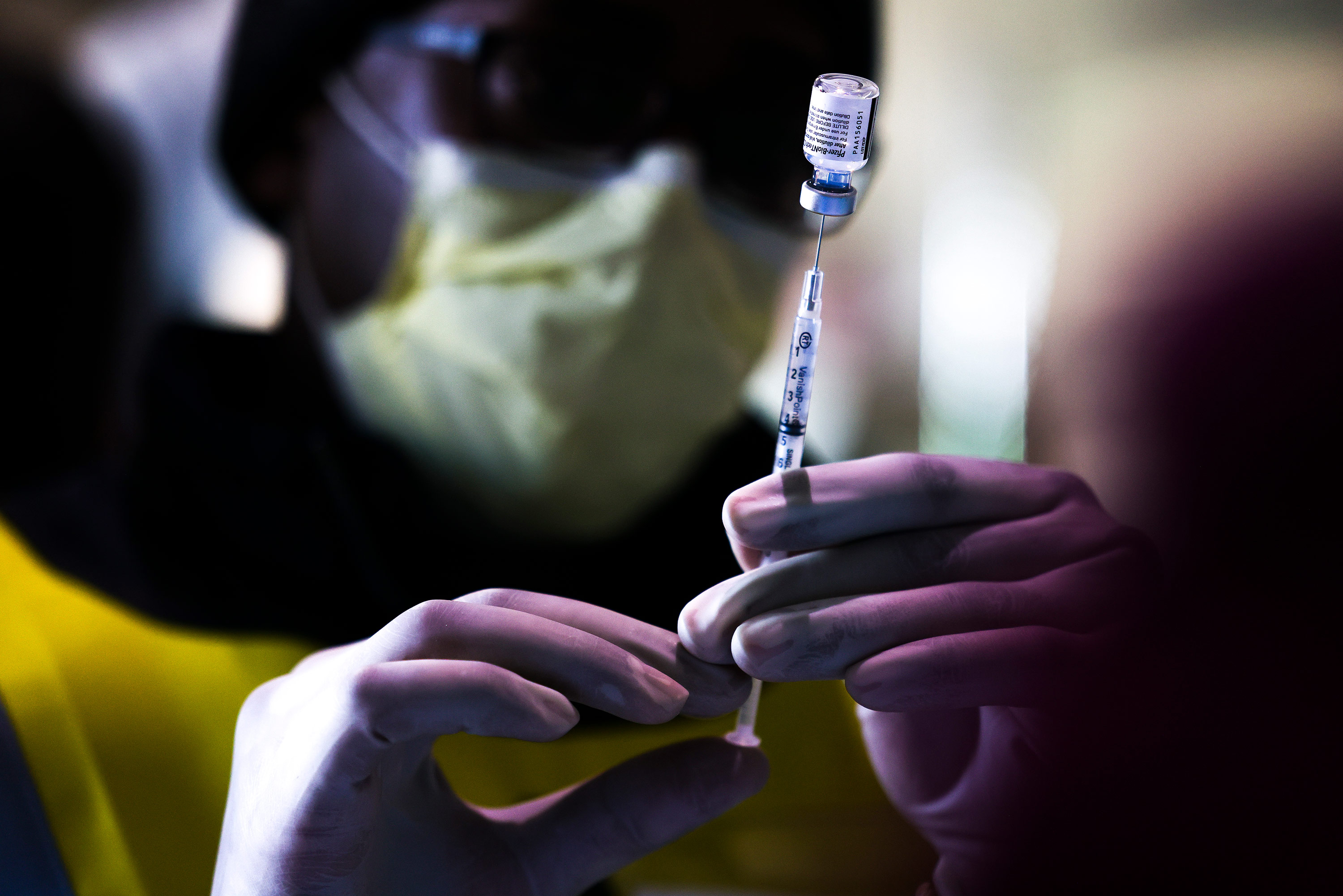 A pharmacy technician prepares doses of the Pfizer-BioNTech vaccine at a mass Covid-19 vaccination event on January 30, in Denver, Colorado. 