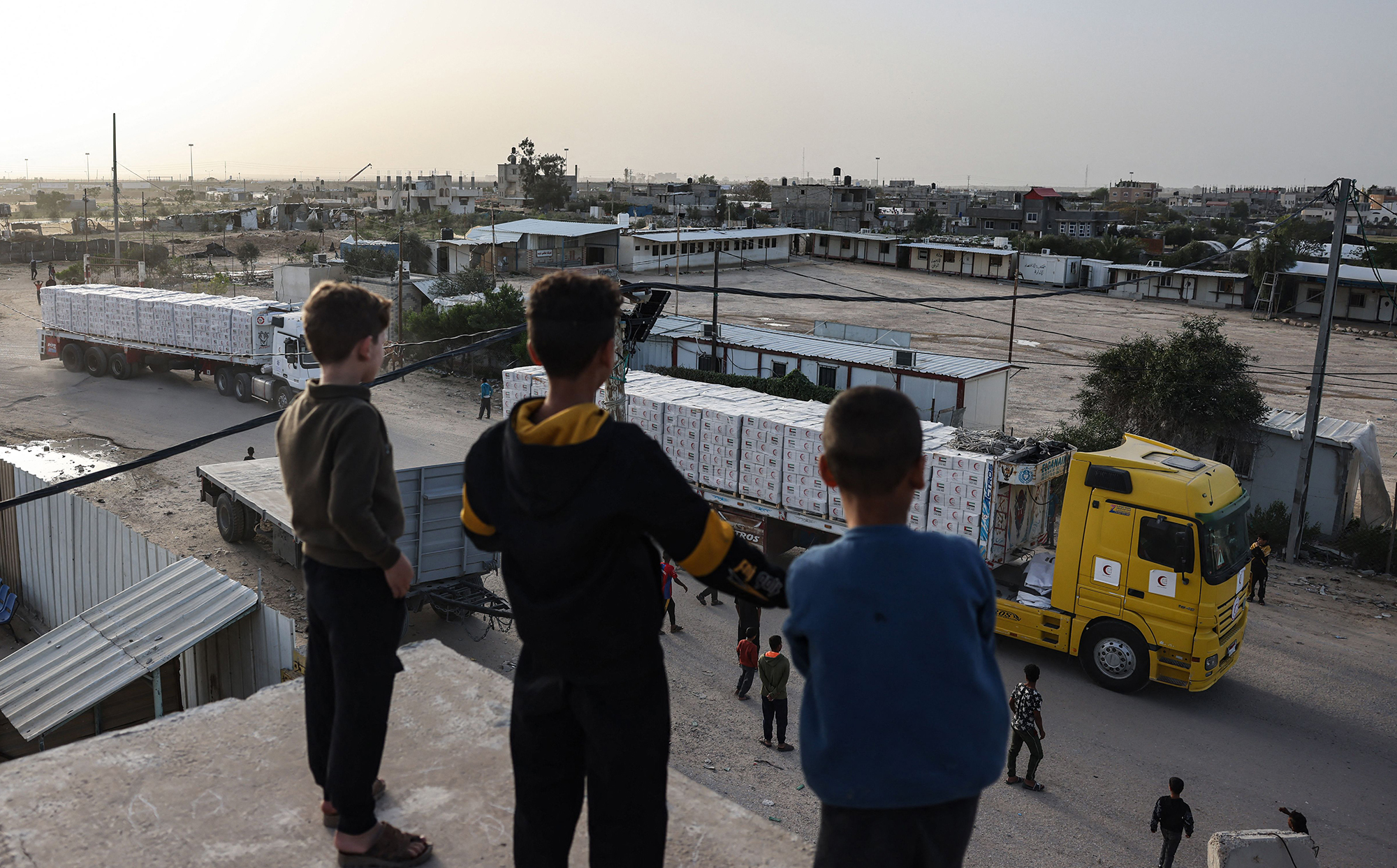 Young boys look at humanitarian aid trucks entering Gaza on November 26. 