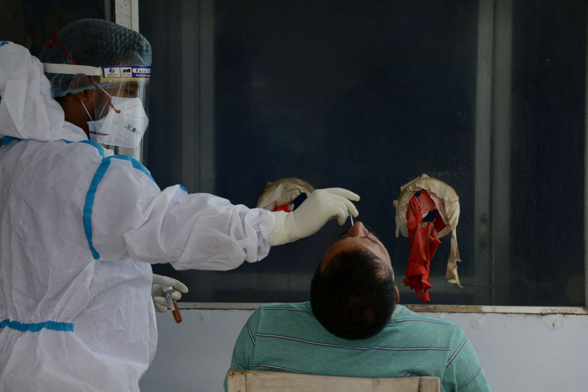 A health worker collects a nasal swab sample for a Covid-19 test at the North Bengal Medical College and Hospital on the outskirts of Siliguri, India on May 13.