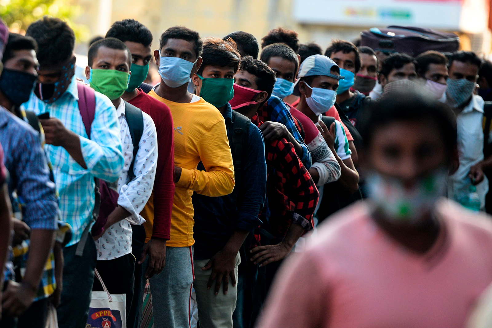 Migrant laborers wait to board a train in Kolkata on July 9.