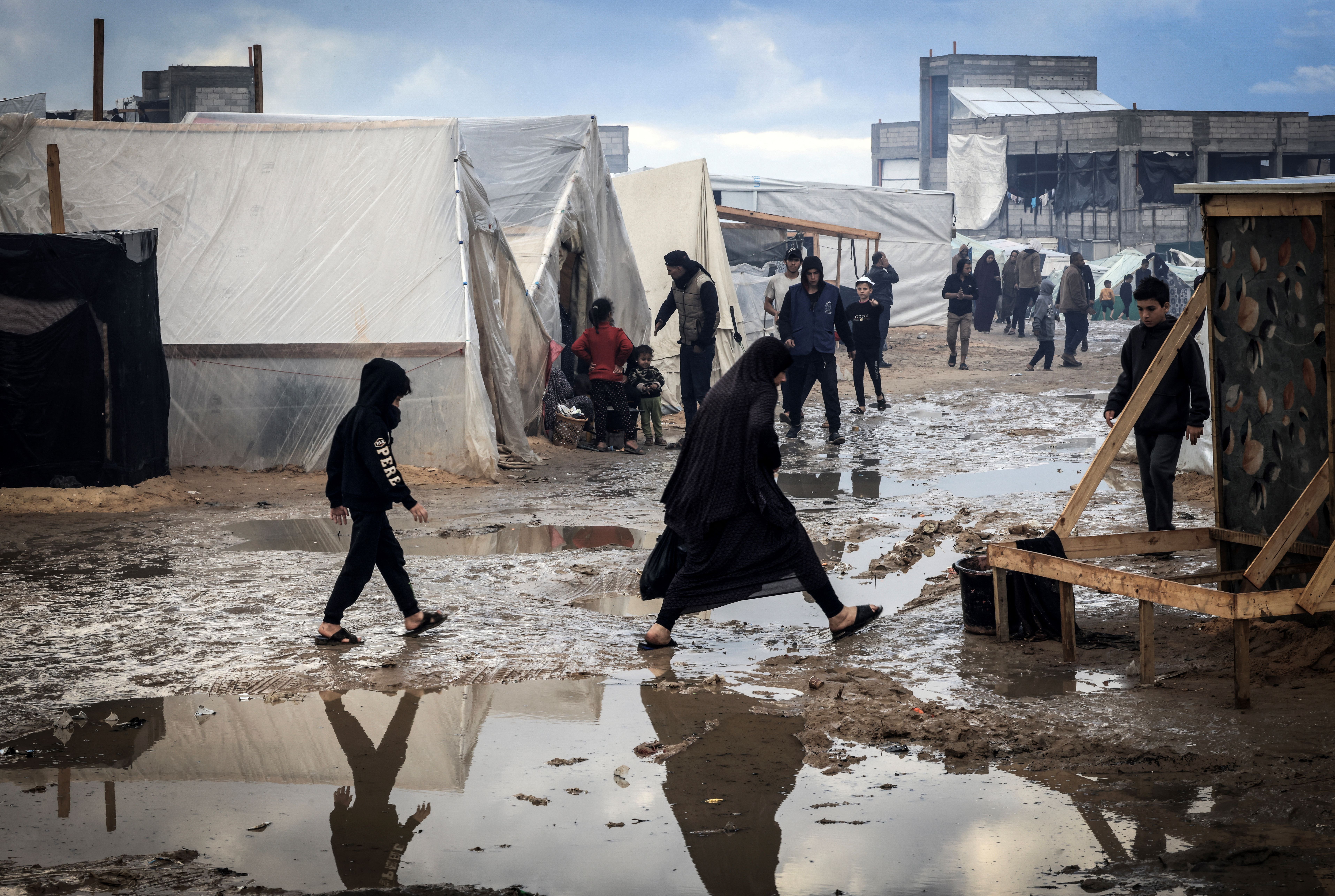 People walk past tents at a makeshift camp housing displaced Palestinians in Rafah, Gaza, on January 2.