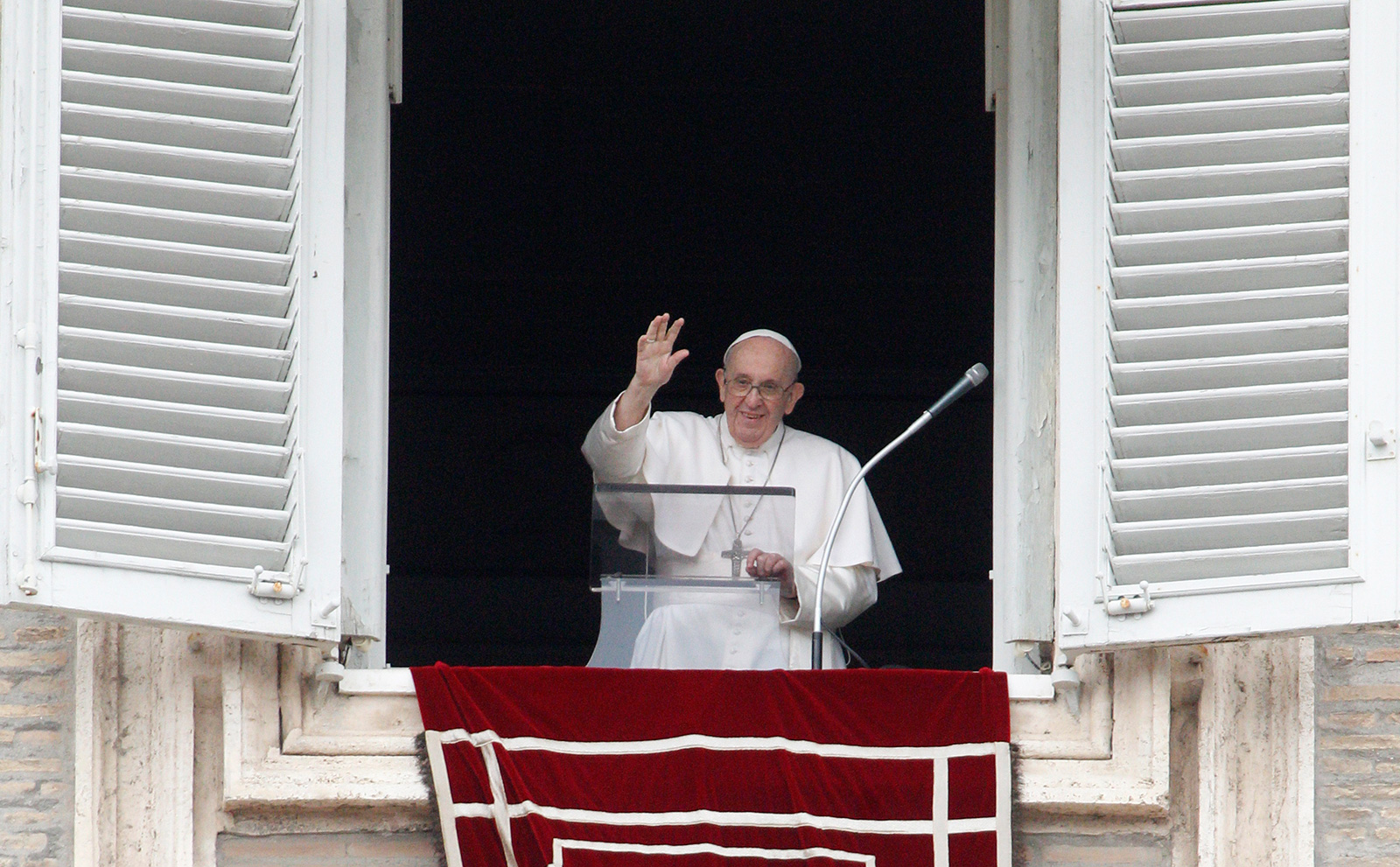 Pope Francis waves from his studio's window overlooking St. Peter's Square to celebrate the Angelus prayer, at the Vatican on Sunday, July 25.