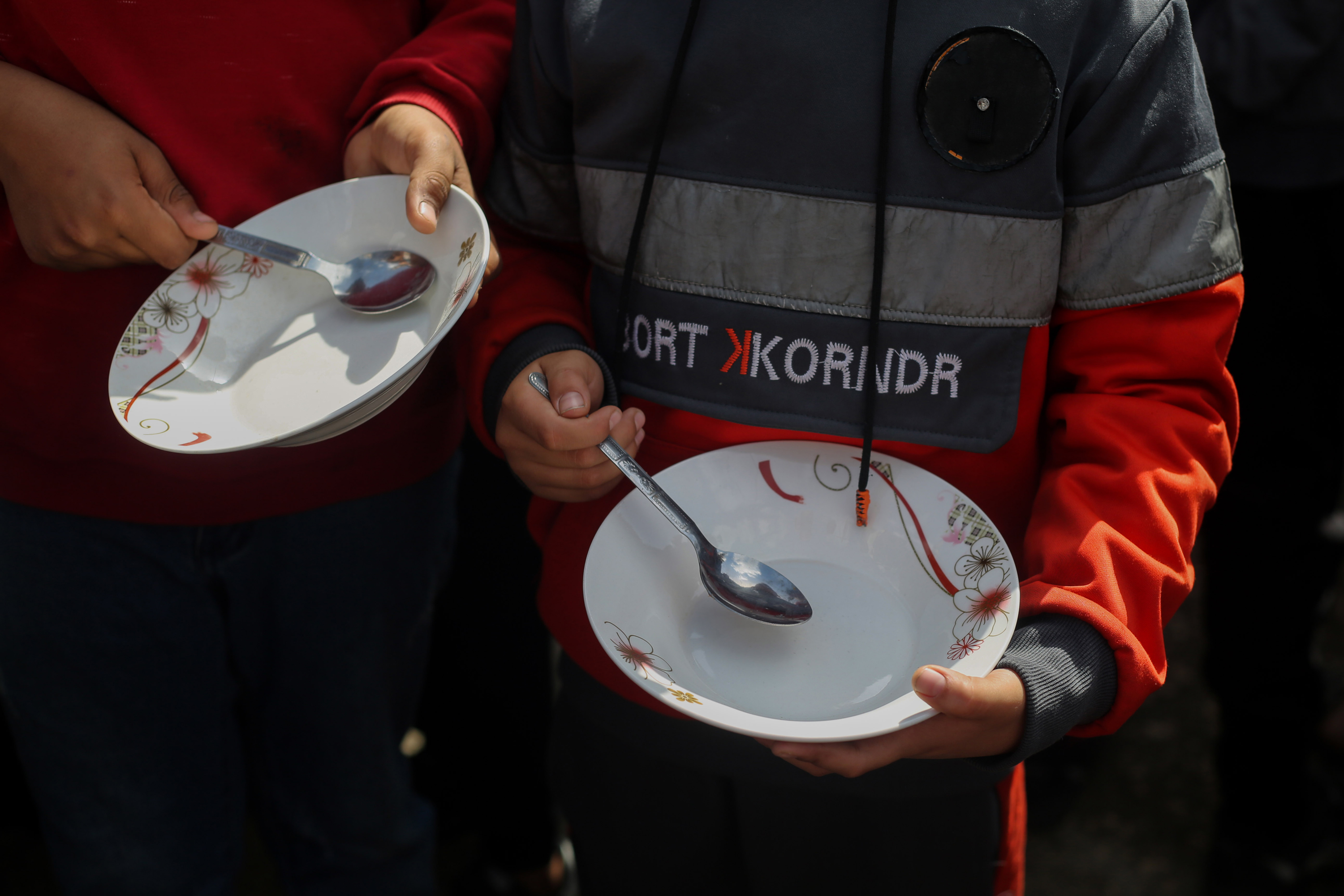 Children carry empty bowls during a march demanding an end to the war and an end to the famine that citizens are suffering from in Rafah, Gaza on March 6.