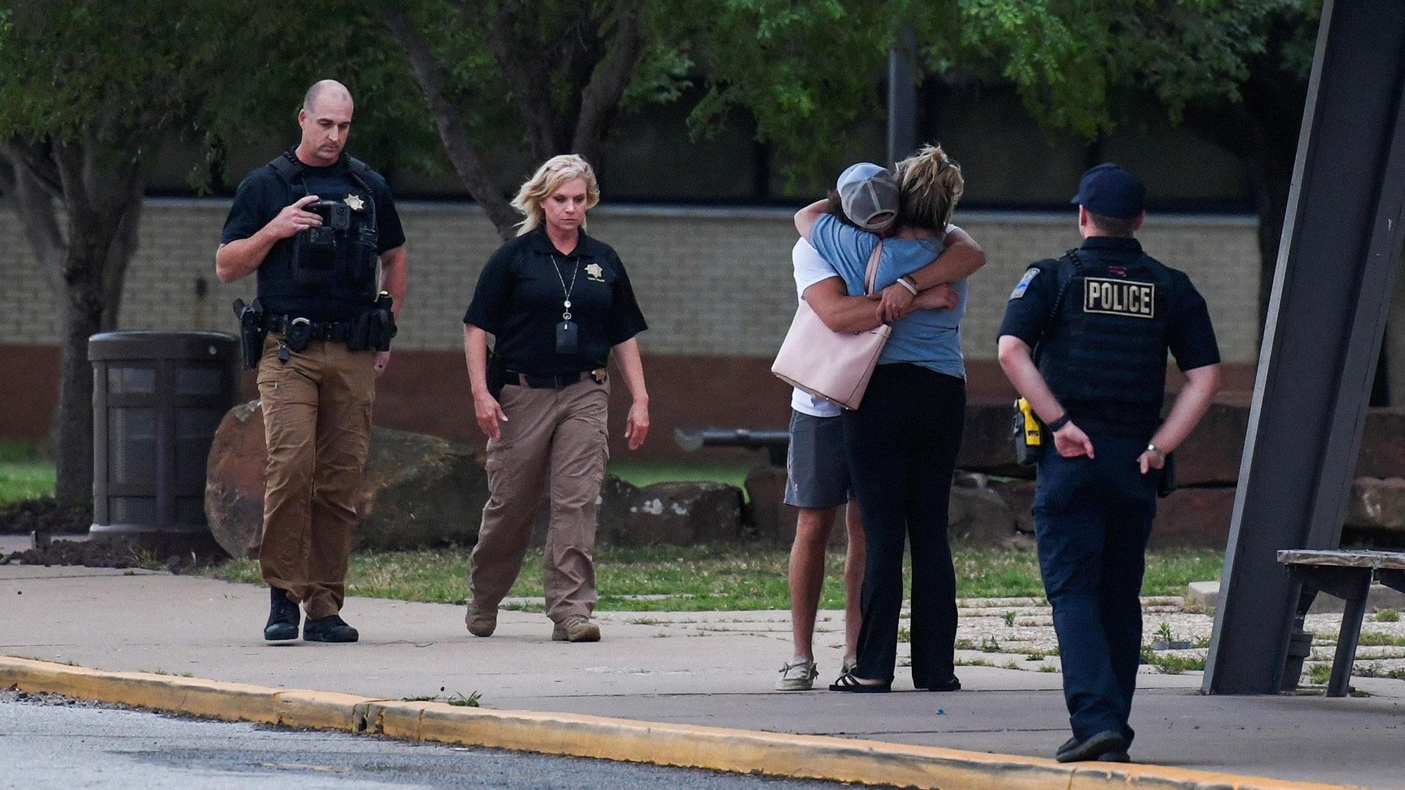 People embrace near the reunion location at Memorial High School following a shooting at Saint Francis hospital campus, in Tulsa, Oklahoma on June 1.