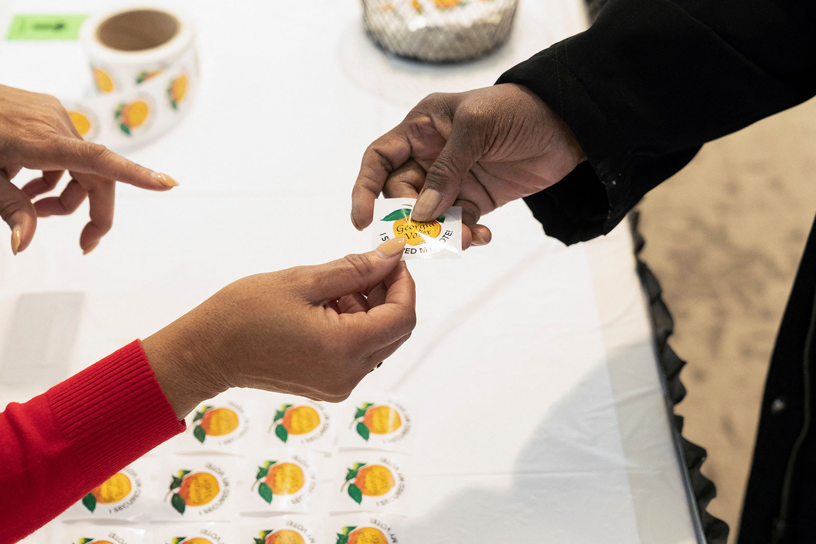 A person receives a sticker that reads 