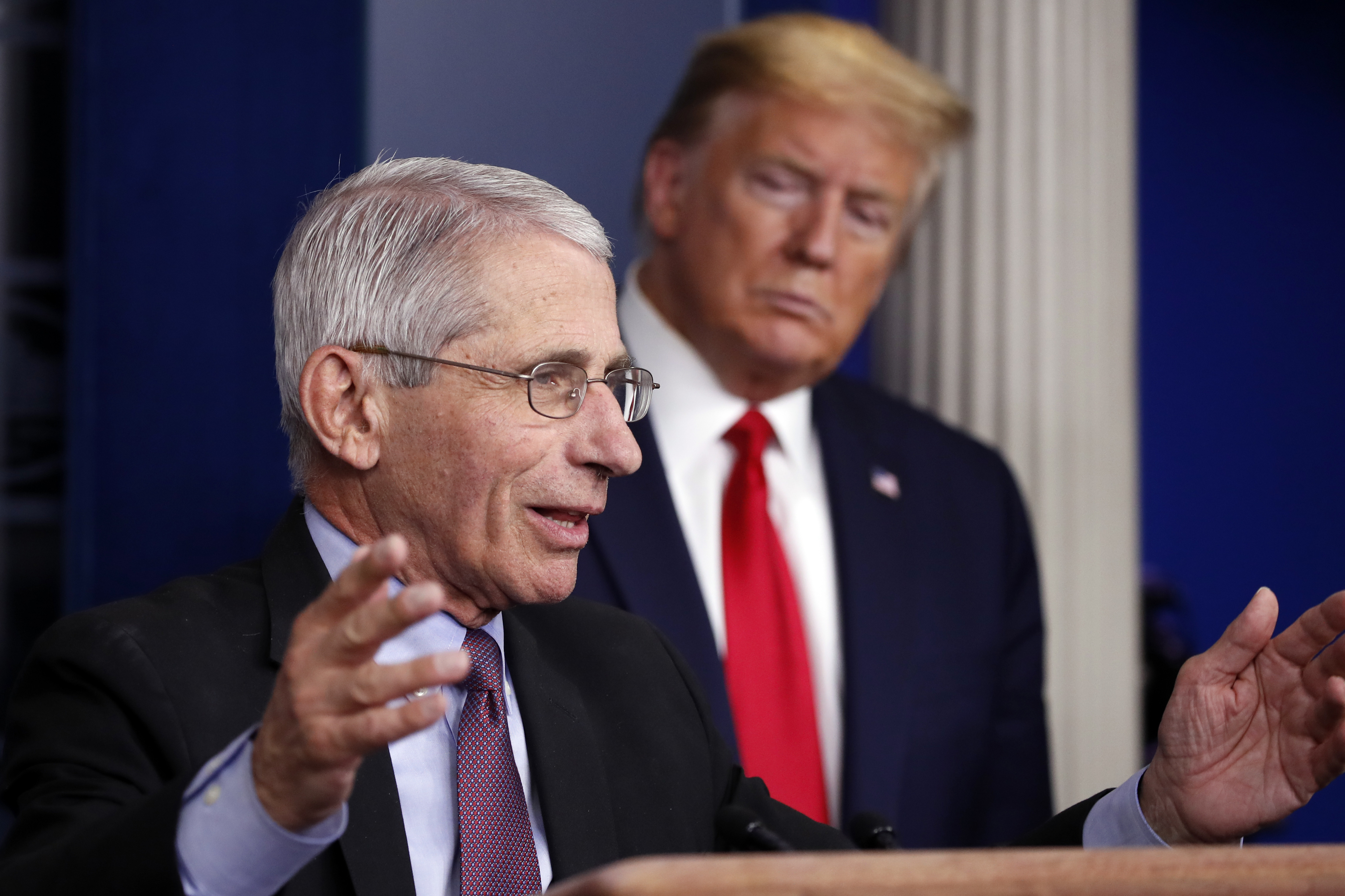 President Donald Trump listens as Dr. Anthony Fauci, the nation's top infectious disease expert, speaks during a briefing about the coronavirus at the White House on April 22.