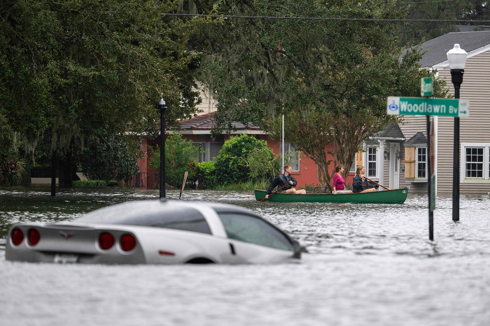 People paddle in a canoe near a submerged vehicle in Orlando, Florida on Thursday.