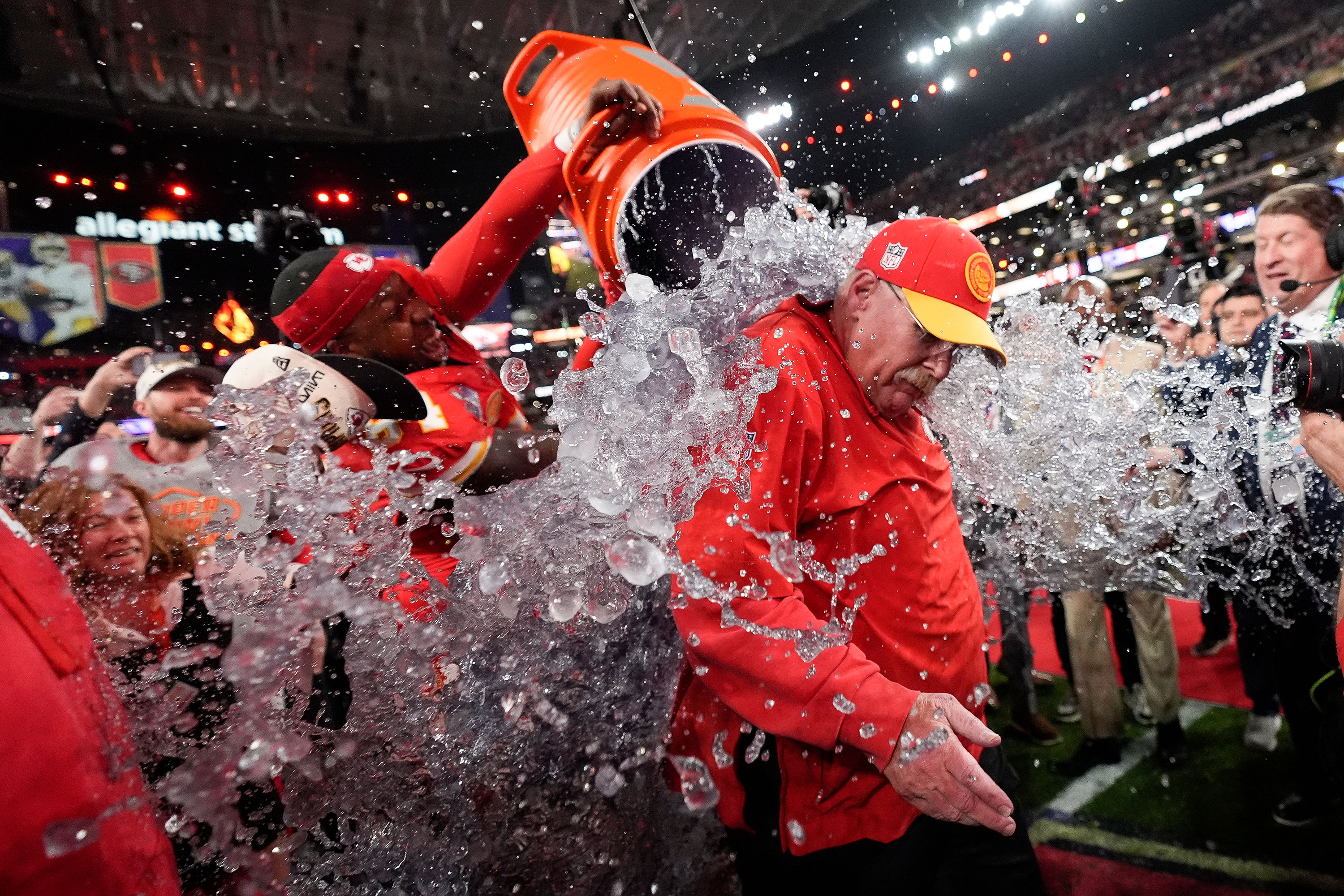 Head coach Andy Reid is splashed by players after the game.