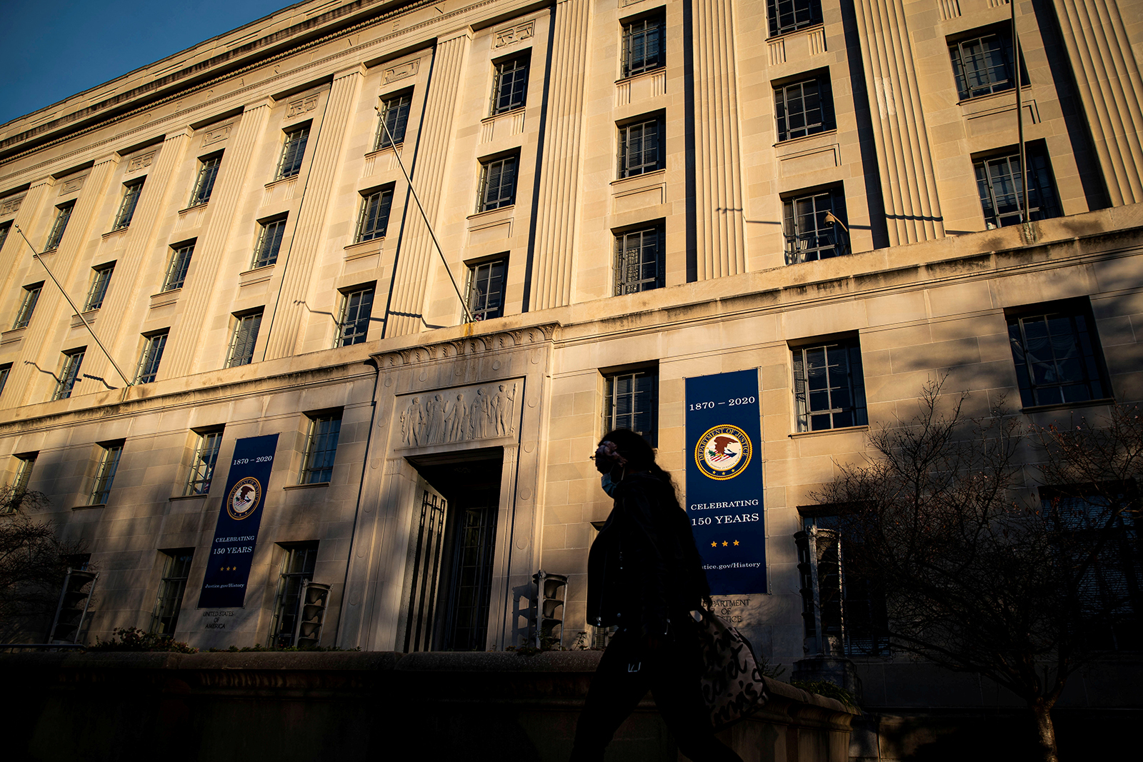 A woman walks past the U.S. Department of Justice Building, in Washington, DC, in December 2020. 