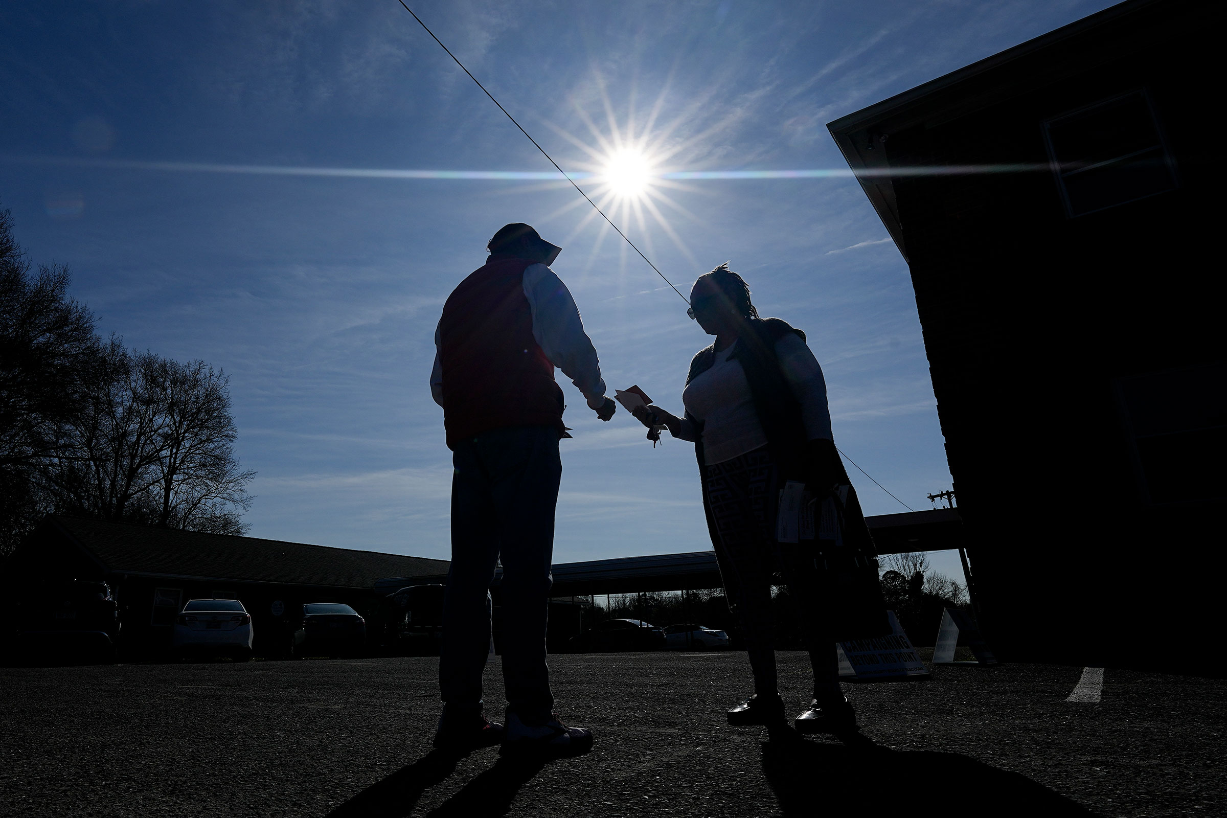 Ron Worley, candidate for Gaston county commissioner, left, talks with a voter on Super Tuesday at the entrance to a polling location on Tuesday, March 5, in Belmont, North Carolina.