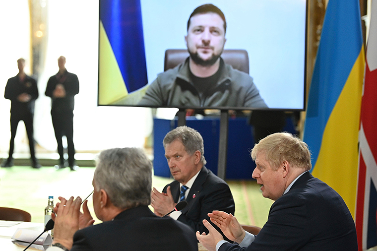 British Prime Minister Boris Johnson and attendees applaud after Ukraine's President Volodymyr Zelensky addressed them by video link during a meeting of the the Joint Expeditionary Force, in London, Tuesday, March 15.