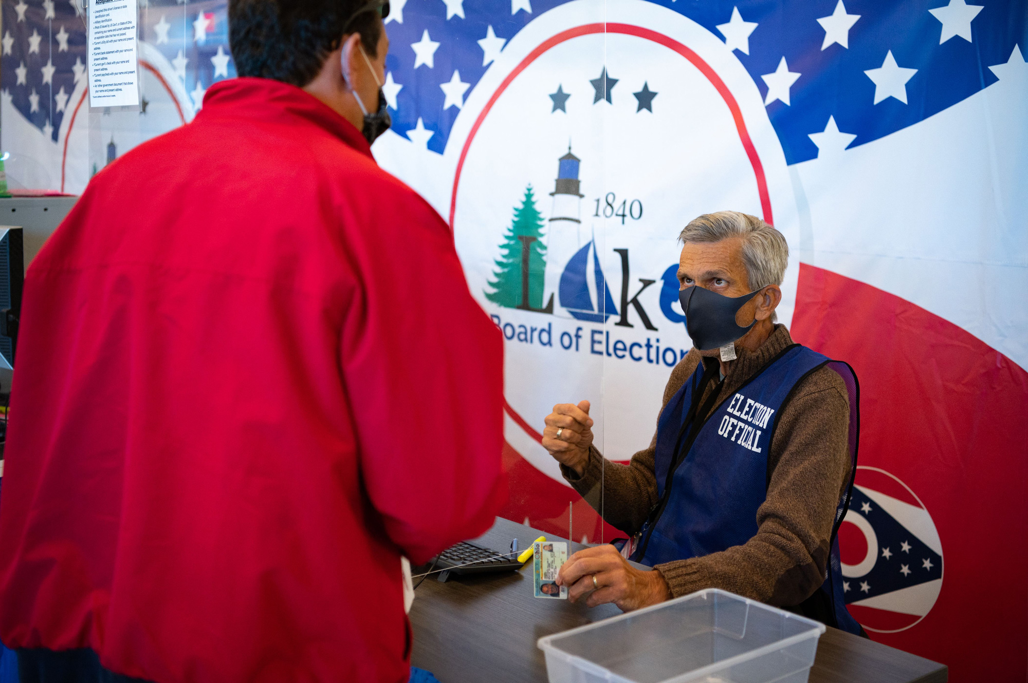 Election official Scott Hagara checks in a voter at the board of elections headquarters during early voting on October 16 in Painesville, Ohio. 