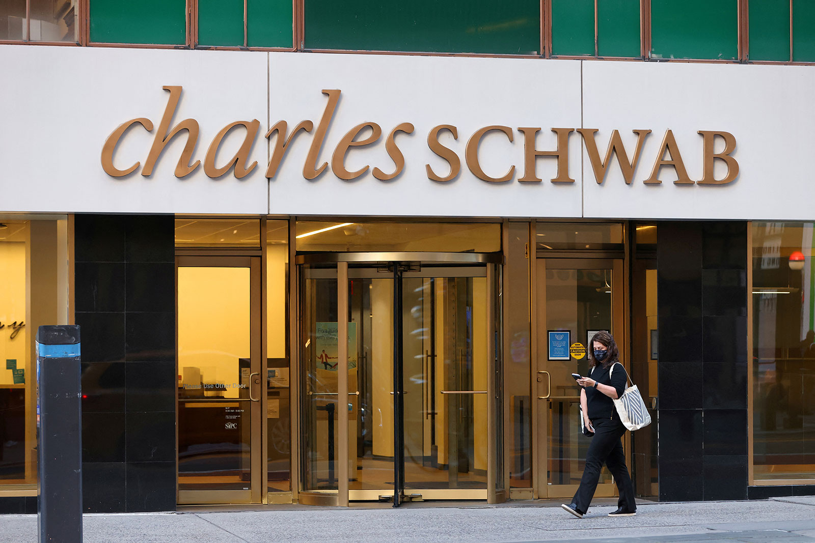 A person walks by a Charles Schwab location in New York, on November 15, 2021. 