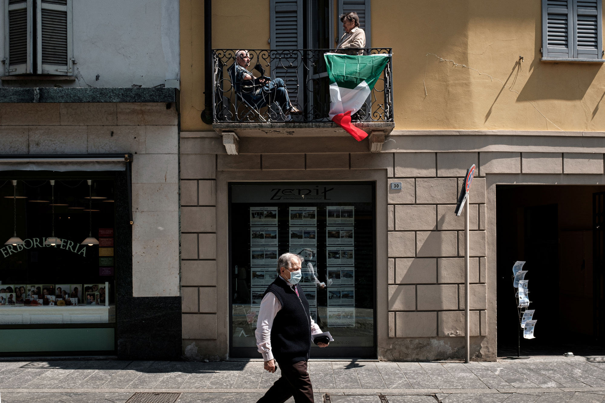 People enjoy the sun from a balcony in Codogno, Italy, on May 4.