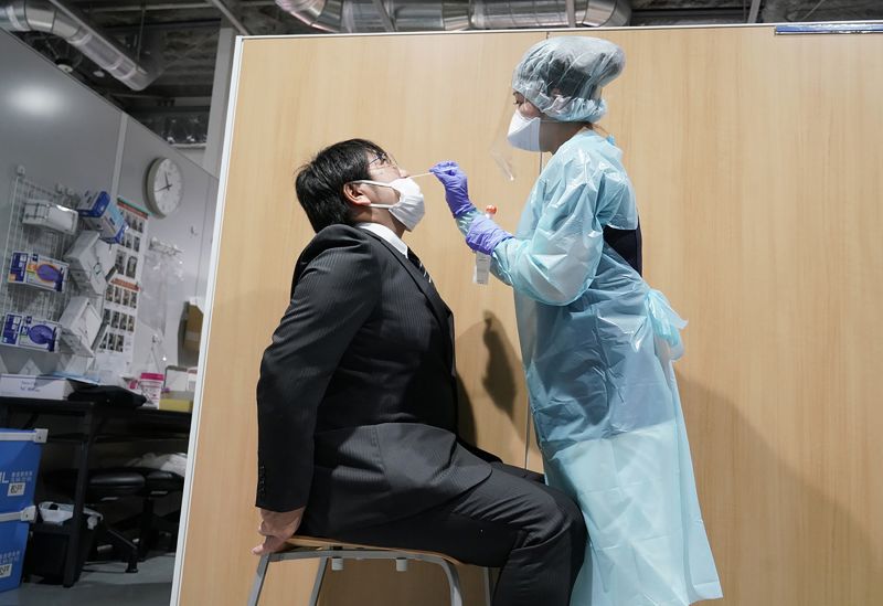 A medical staff member conducts a demonstration to test for the Covid-19 coronavirus at the testing centre of Narita Airport in Narita on November 2. 