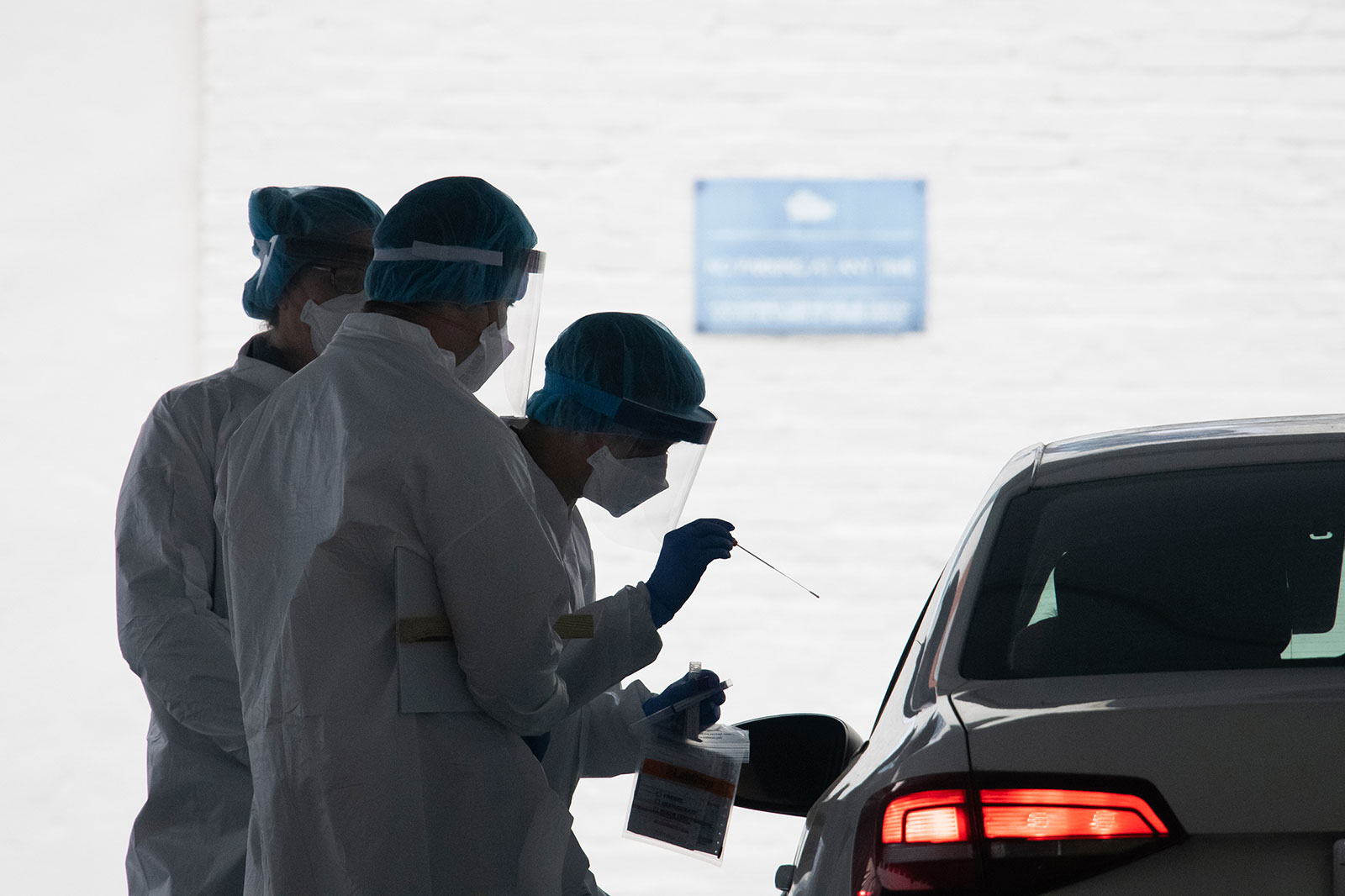 A healthcare worker administers a coronavirus test at a drive-through testing facility at George Washington University in Washington, DC, last month.