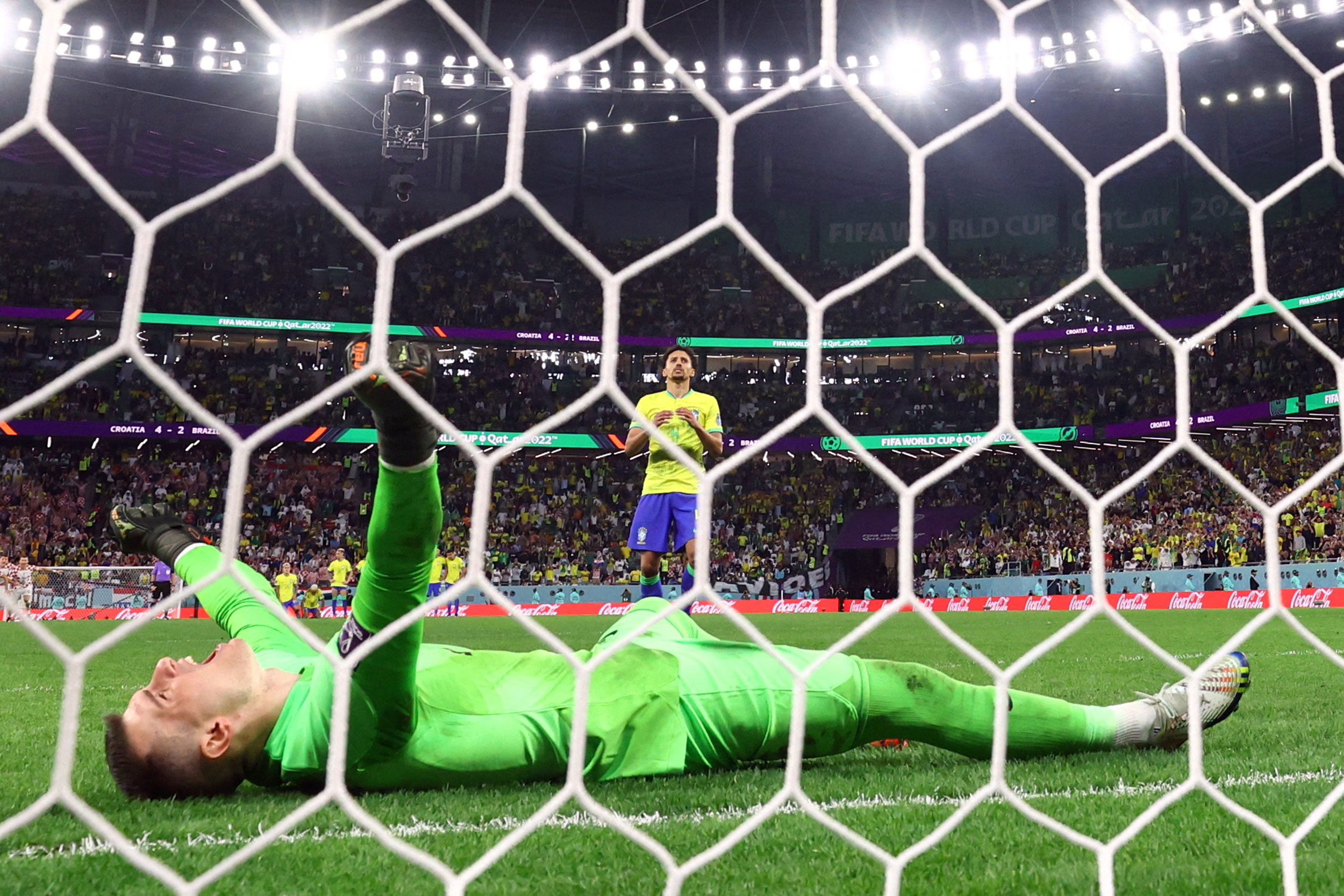 Croatia goalkeeper Domini Livaković celebrates after Brazil’s Marquinhos’ penalty shot deflected off the post to secure victory for Croatia.