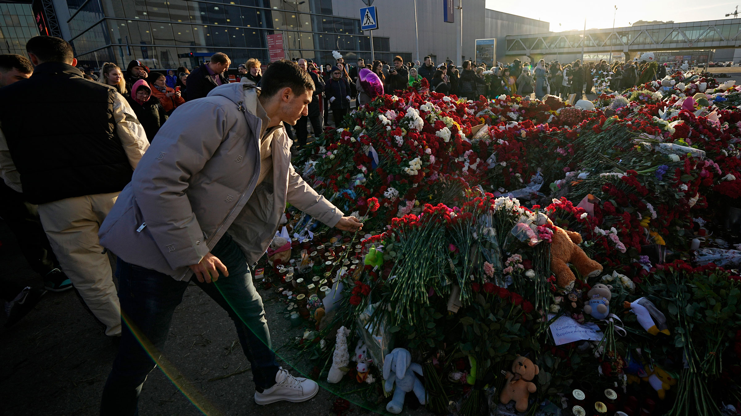 People place flowers at a makeshift memorial in front of the Crocus City concert hall on Monday.