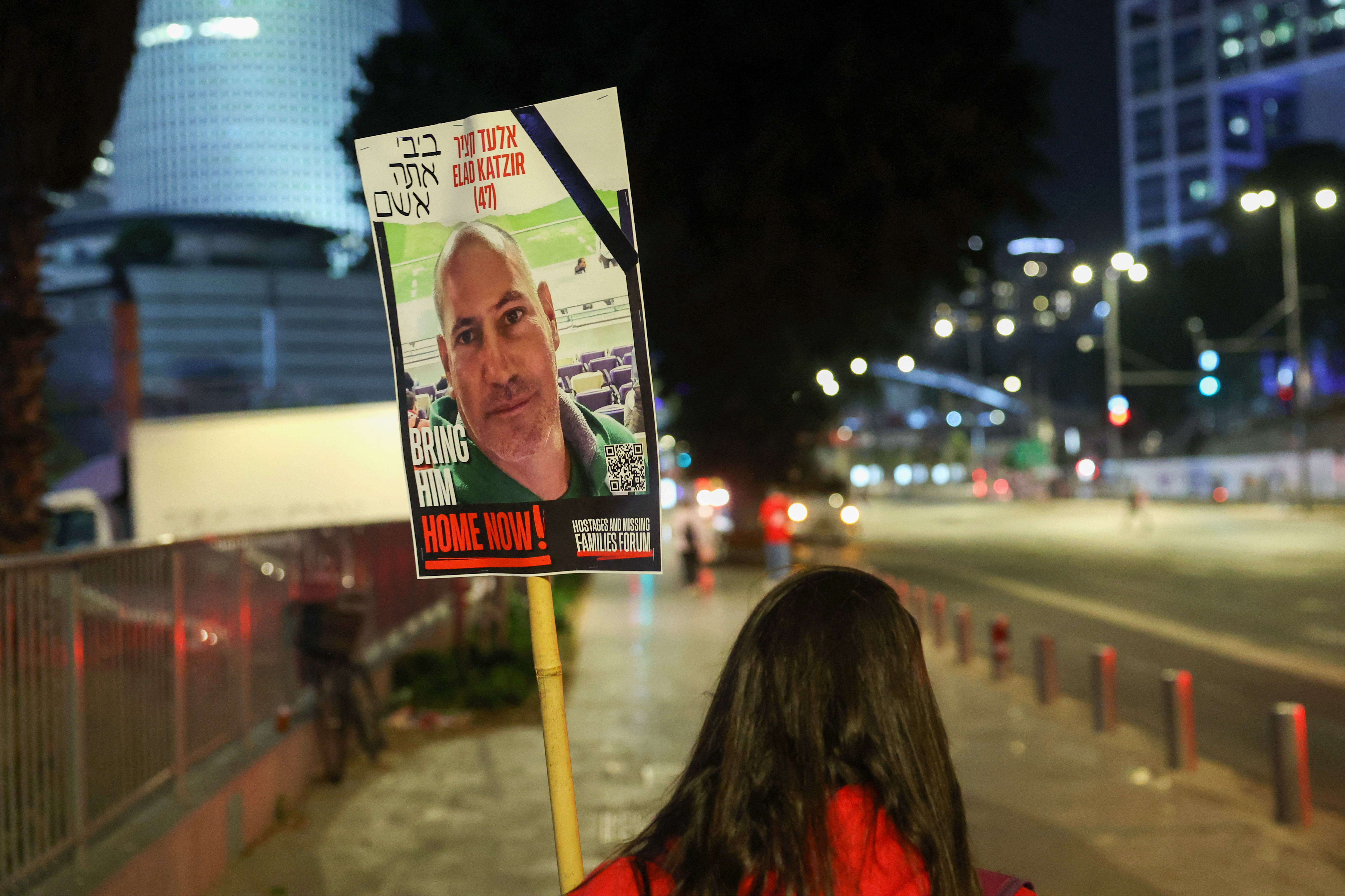 A person holds a sign with a photo of Elad Katzir near the Ministry of Defense in Tel Aviv, Israel, on April 6, during a demonstration for relatives and supporters of Israeli hostages held in Gaza.