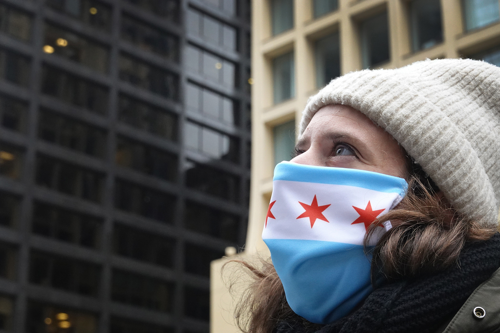 Lydia Ross, director of public art for the city of Chicago, watches as a mask with a depiction of the Chicago flag is placed on the Picasso statue in Daley Plaza on April 30, in Chicago.