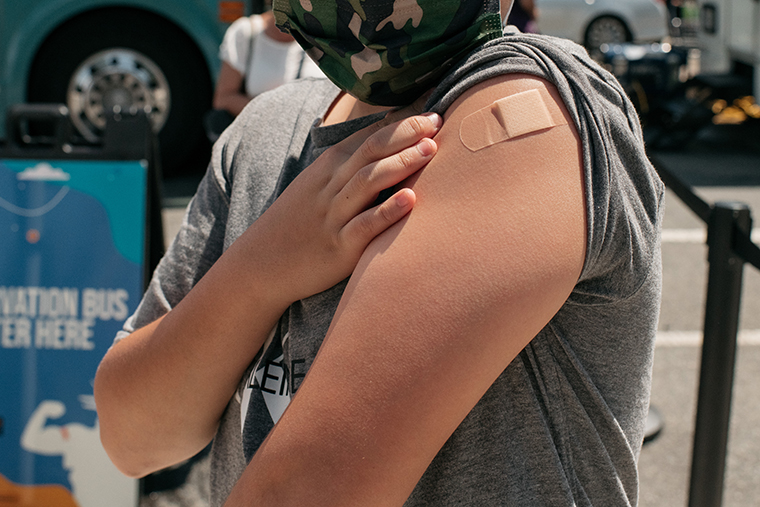 A 13-year-old newly vaccinated against COVID-19 shows his bandage at a pop-up vaccination site on June 5, 2021 in the Queens borough in New York City. 