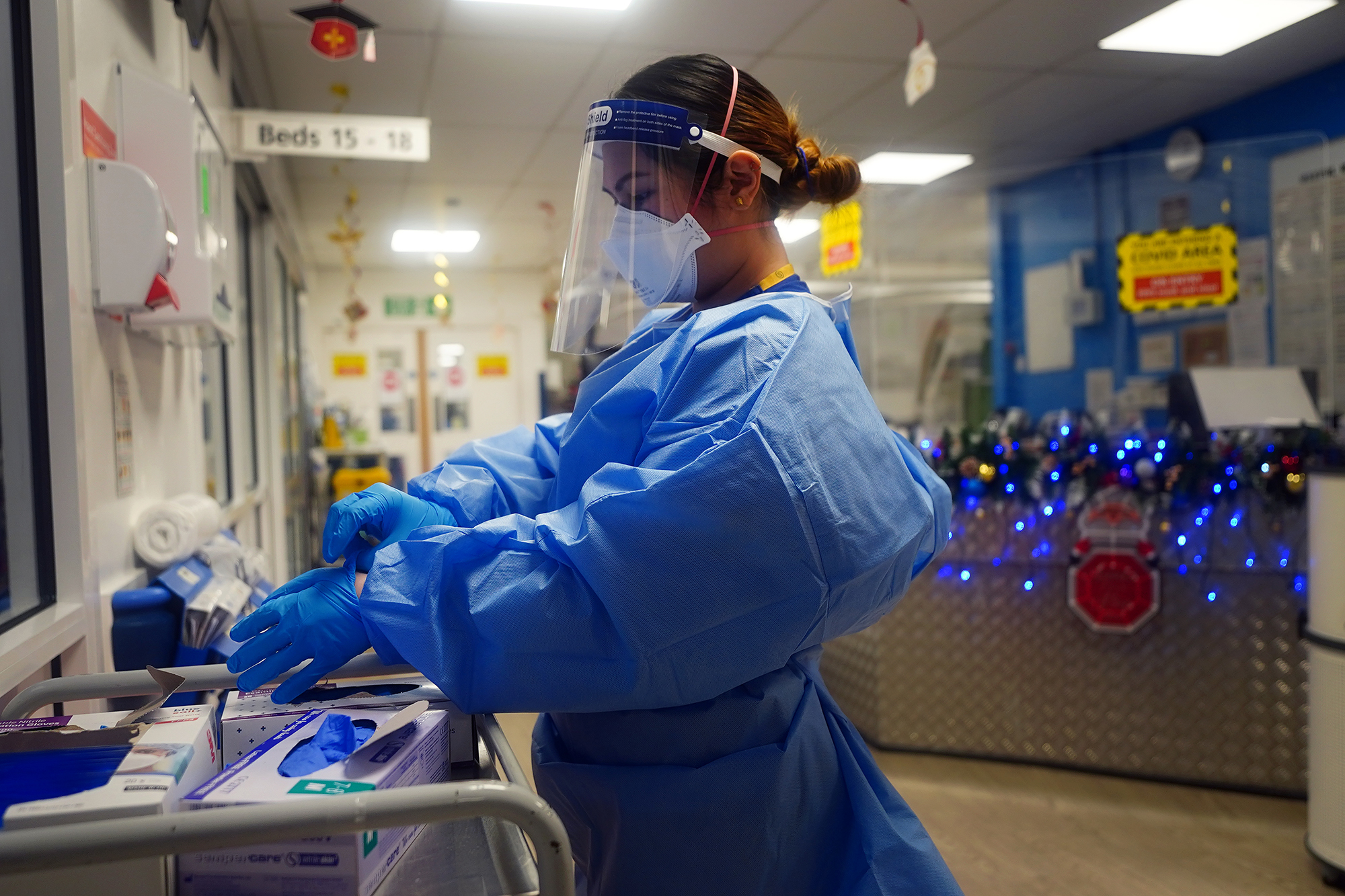 A nurse puts on PPE at a ward for Covid patients at London's King's College Hospital, on December 21, 2021. 