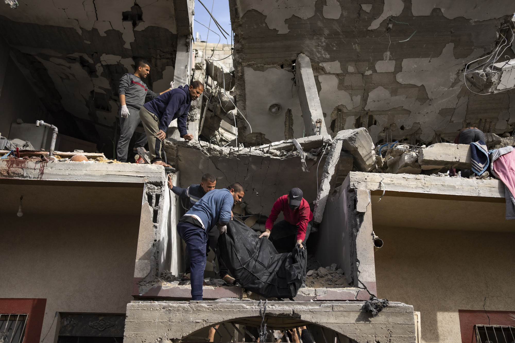 Palestinians carry the body of a woman found under the rubble of a destroyed building following an Israeli airstrike in Rafah, Gaza, on Wednesday.