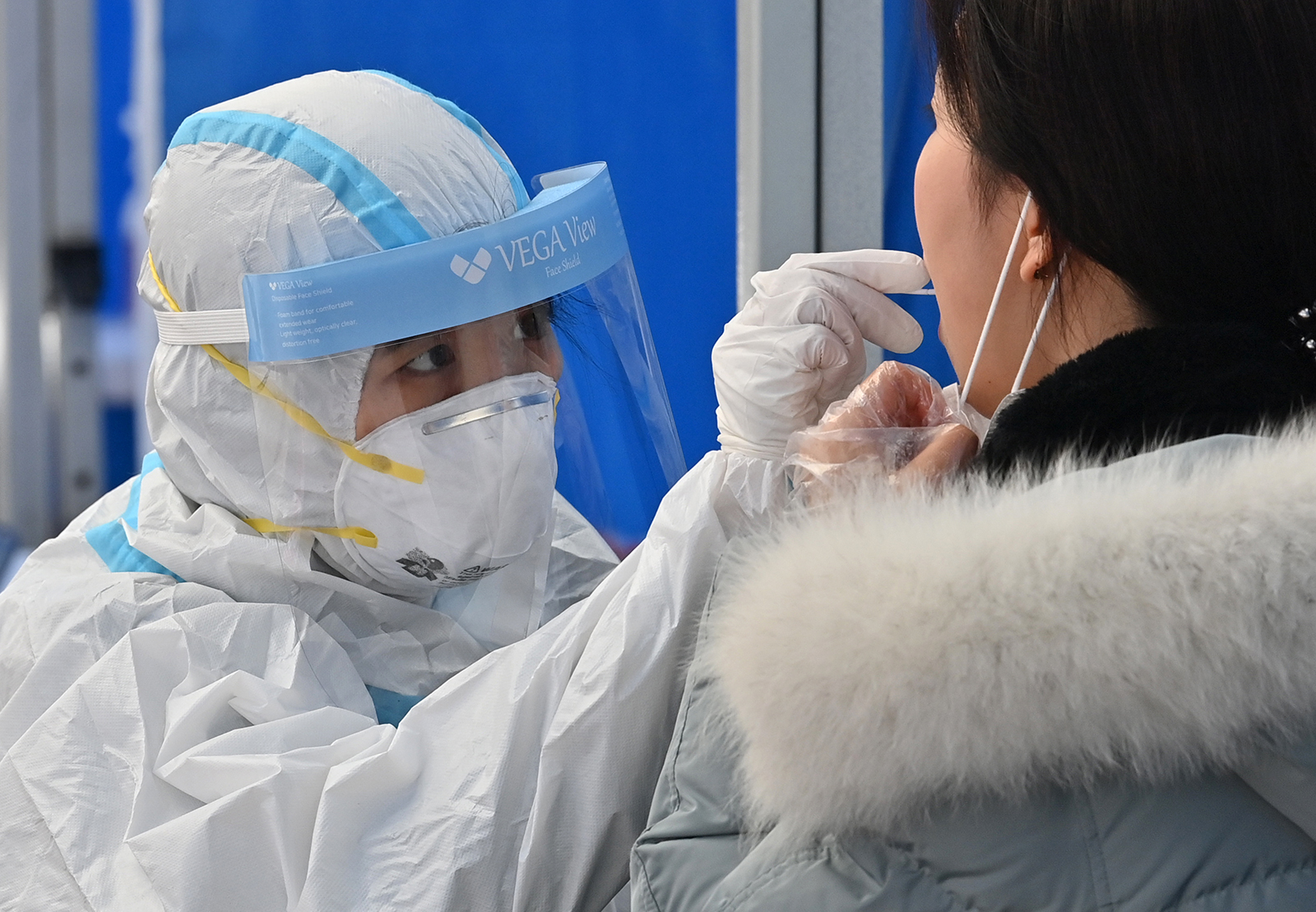 A medical worker takes samples from a visitor at a coronavirus testing station in Seoul, South Korea, on November 27.