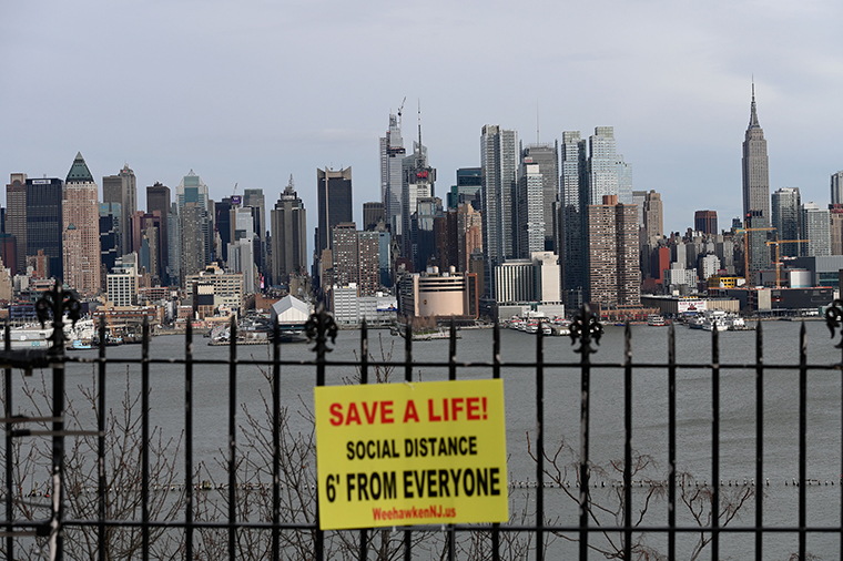 A sign hangs in a park overlooking the Manhattan skyline on April 2, 2020 as seen from Weehawken, New Jersey, on Thursday, April 2.