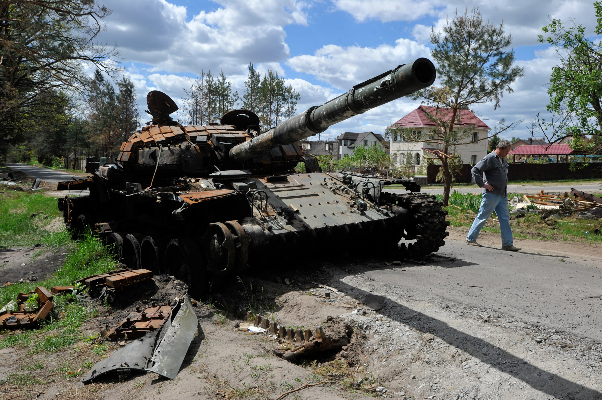 A man walks past a destroyed Russian tank in the village of Mykolaivka in the Kyiv Region, on May 17.