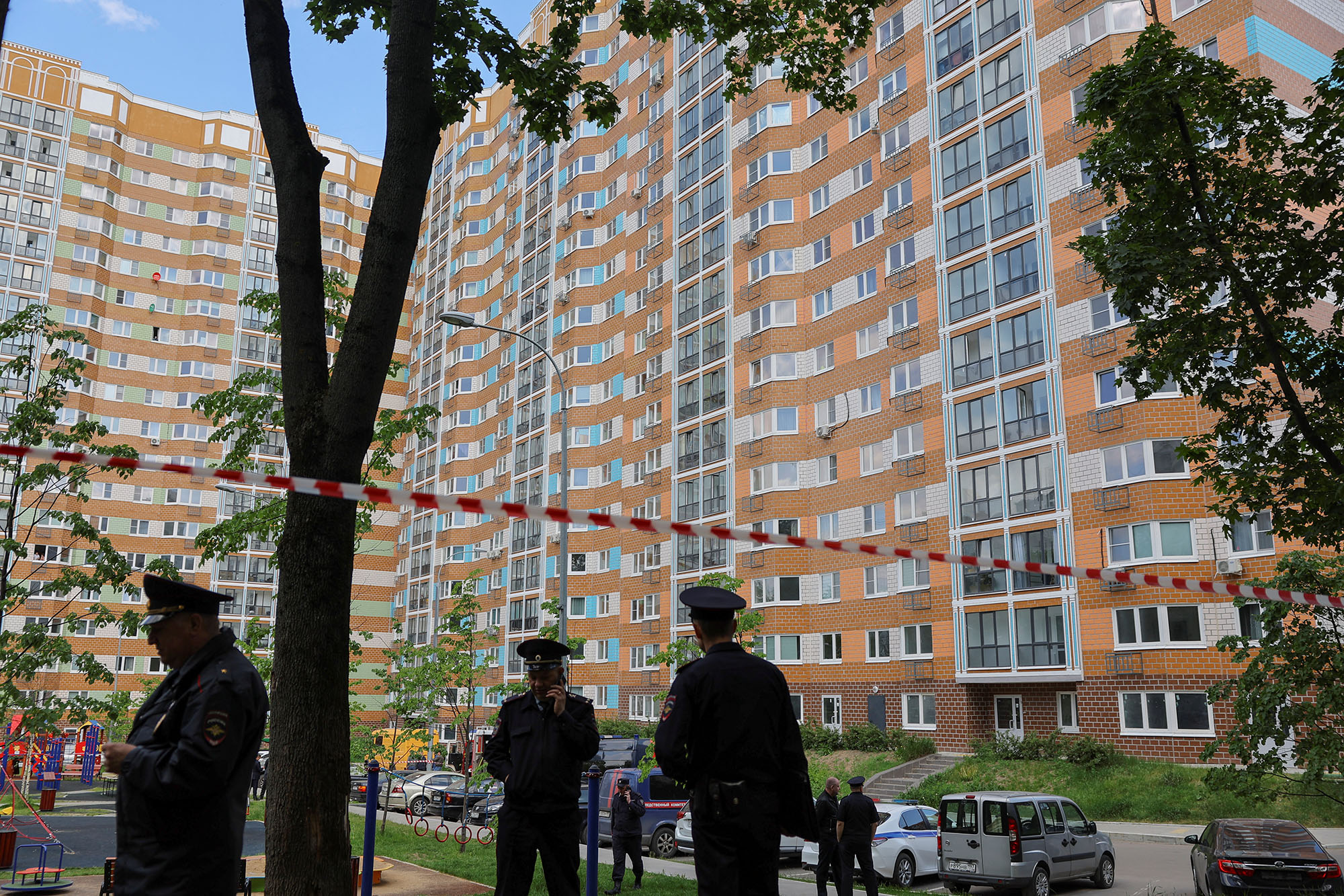Russian law enforcement officers stand guard near a damaged multi-storey apartment block following a reported drone attack in Moscow, Russia, on May 30.