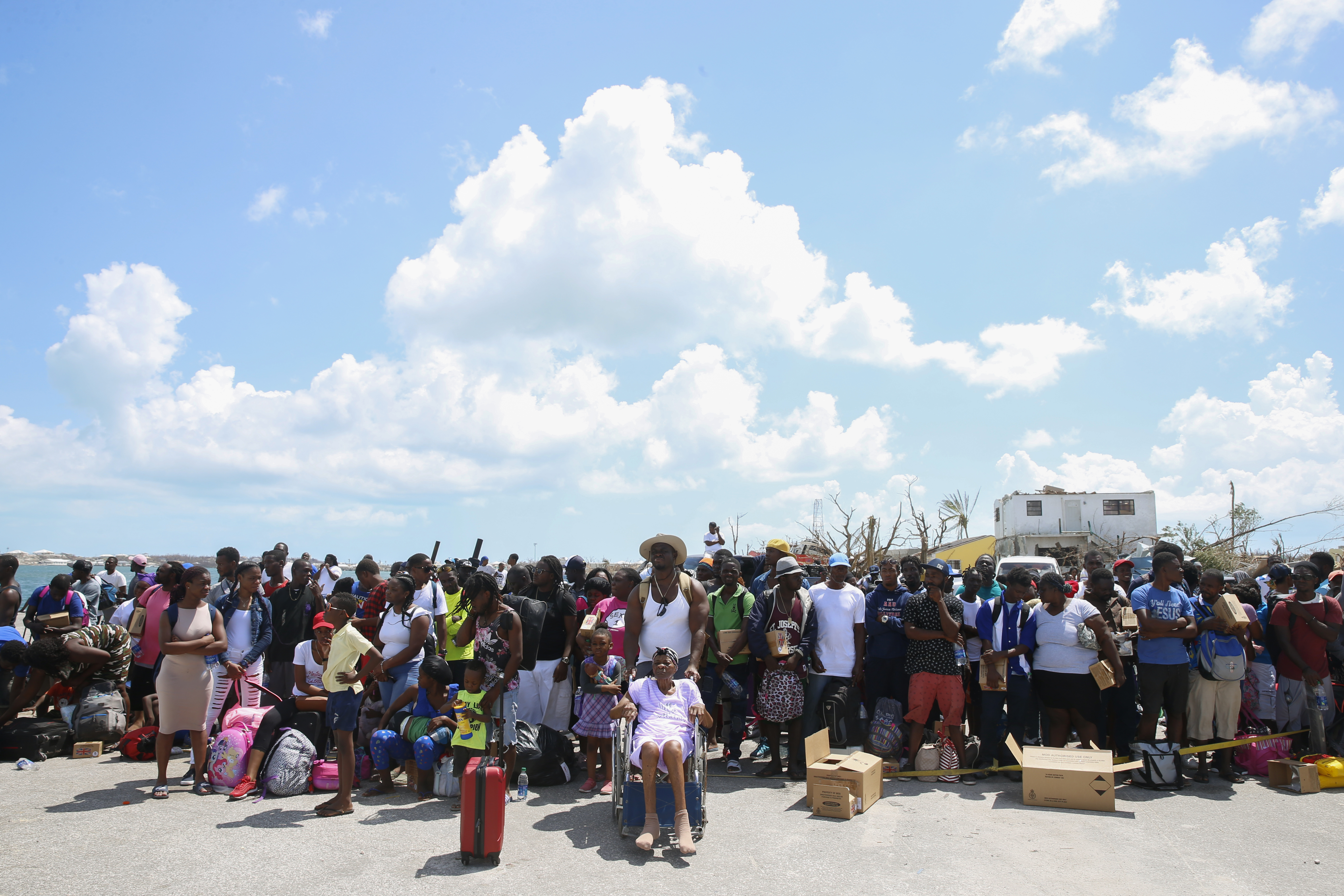 People wait to evacuated in private boats at the Marsh Harbor Port.