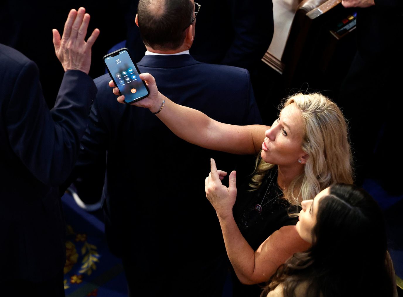 U.S. Representative Marjorie Taylor-Greene, a Republican from Georgia, holds a phone with the initials "DT" on screen Friday night.  His spokesperson confirmed it was former President Donald Trump on the phone.